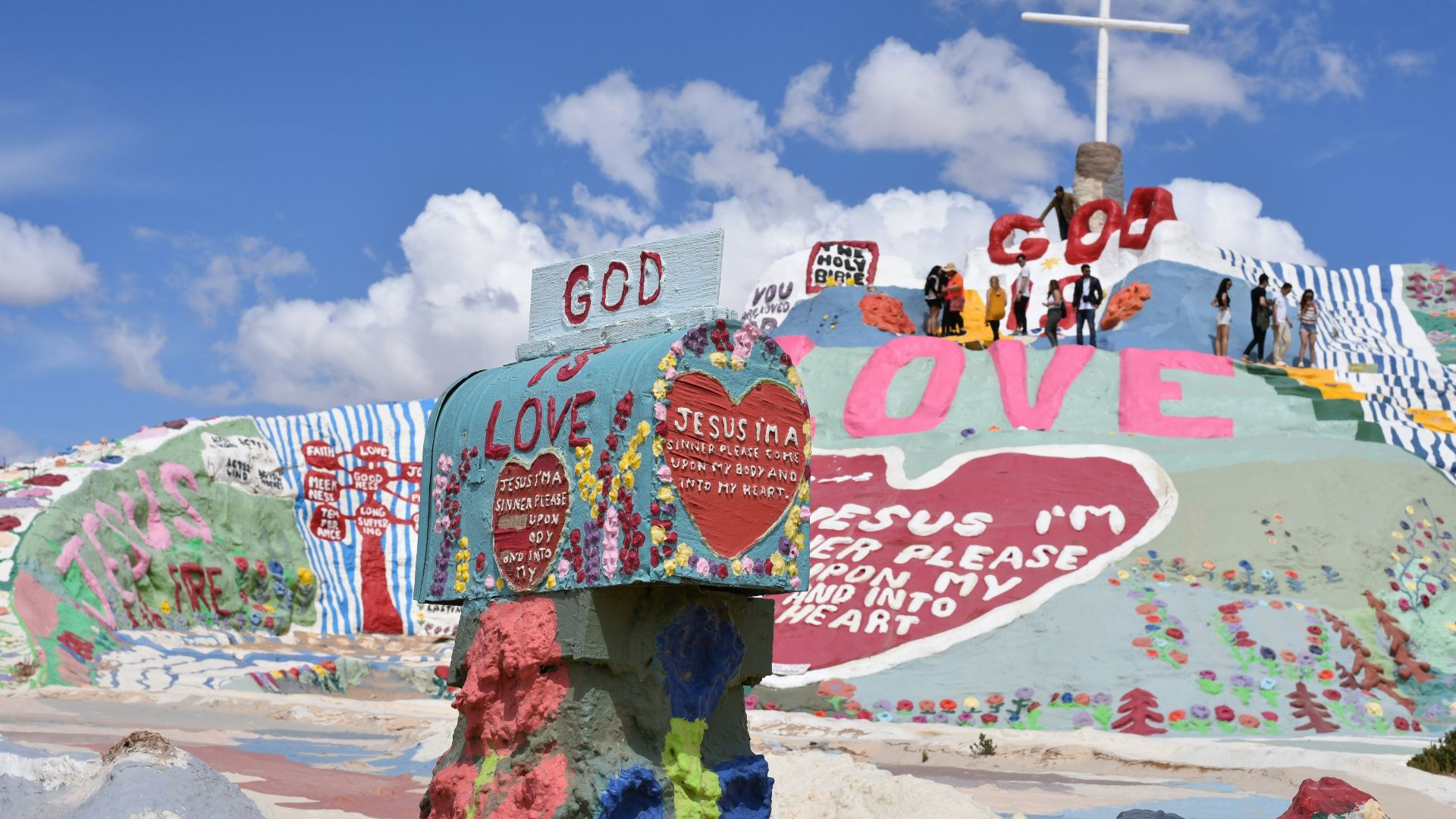 multicolored God is Love paintings under clear blue sky