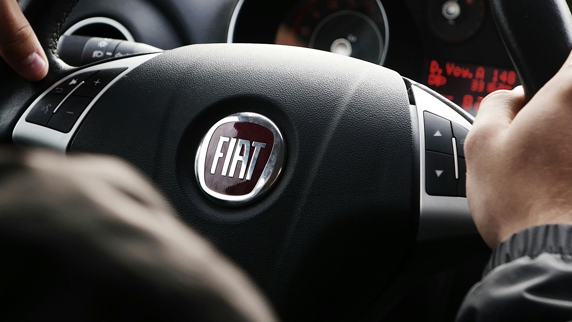 person riding FIAT car during daytime