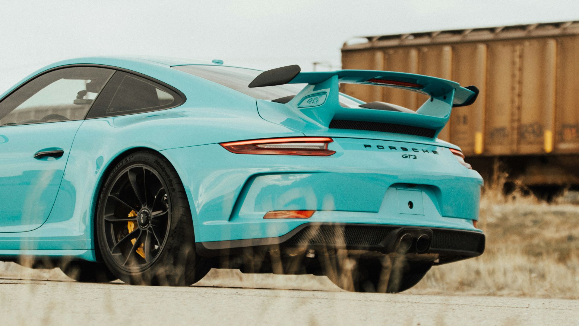 teal sedan beside trailer truck