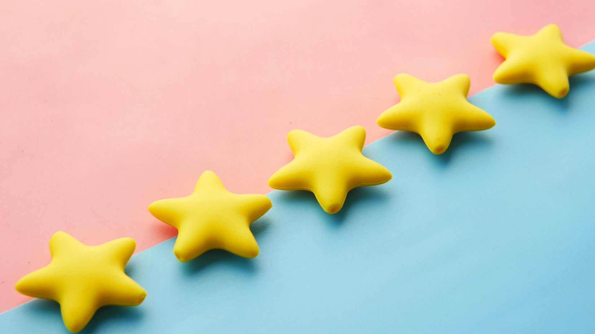 a row of yellow stars sitting on top of a blue and pink surface