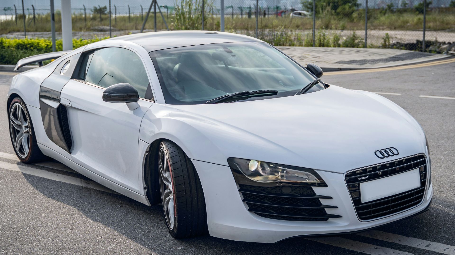 white audi r 8 parked on parking lot during daytime