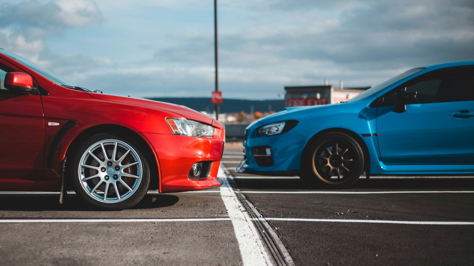 blue and red cars in parking lots