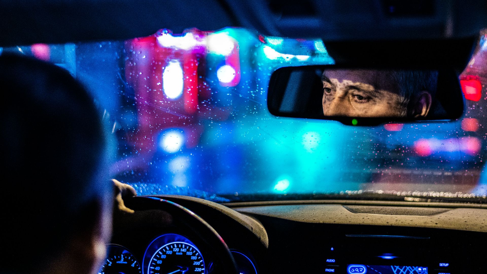 reflective photo of man in rearview mirror