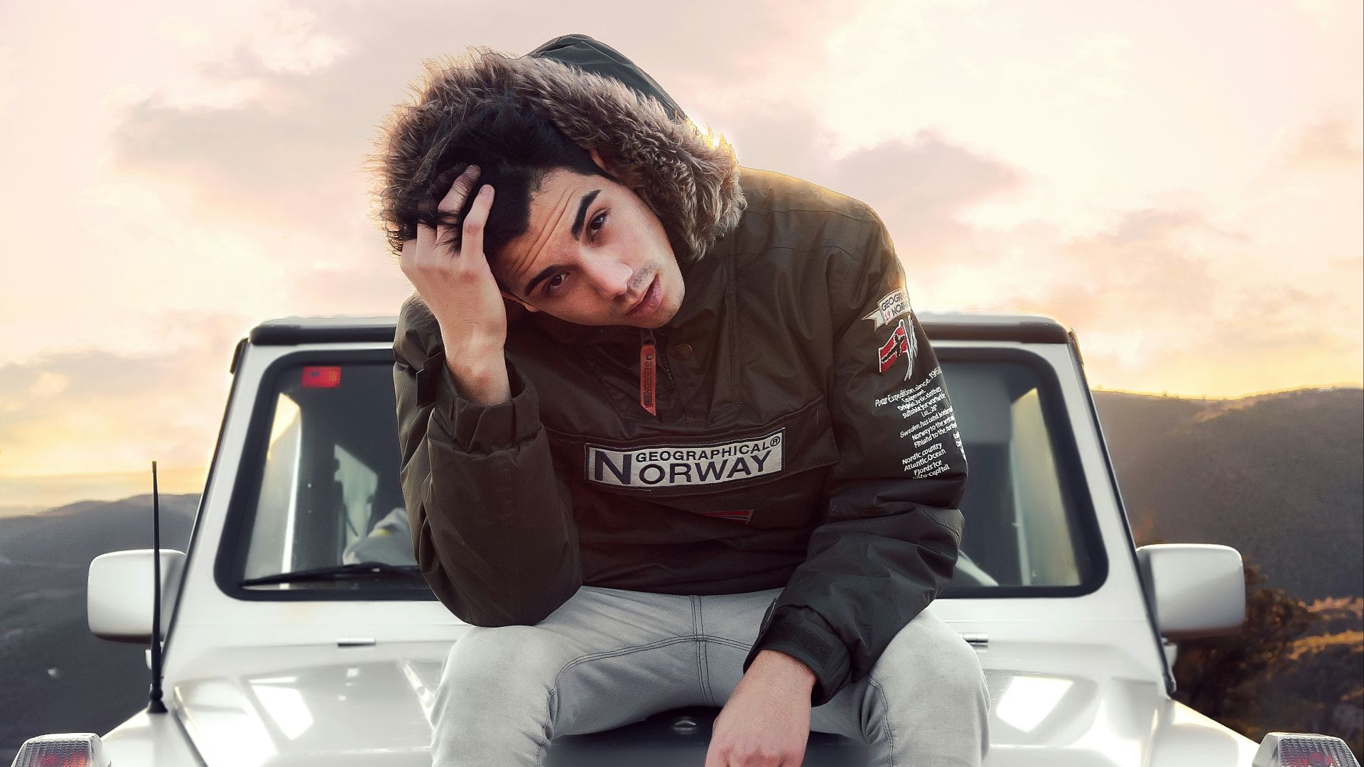 man sitting on silver Mercedes-Benz vehicle