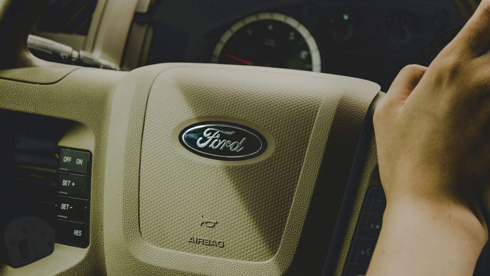 person holding Ford steering wheel