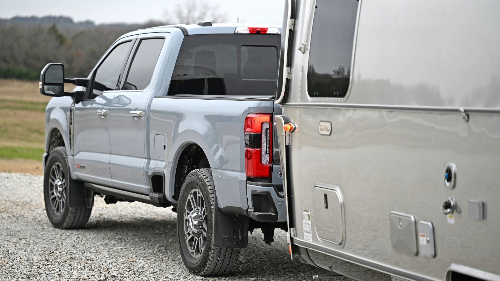 A silver truck parked on a gravel road