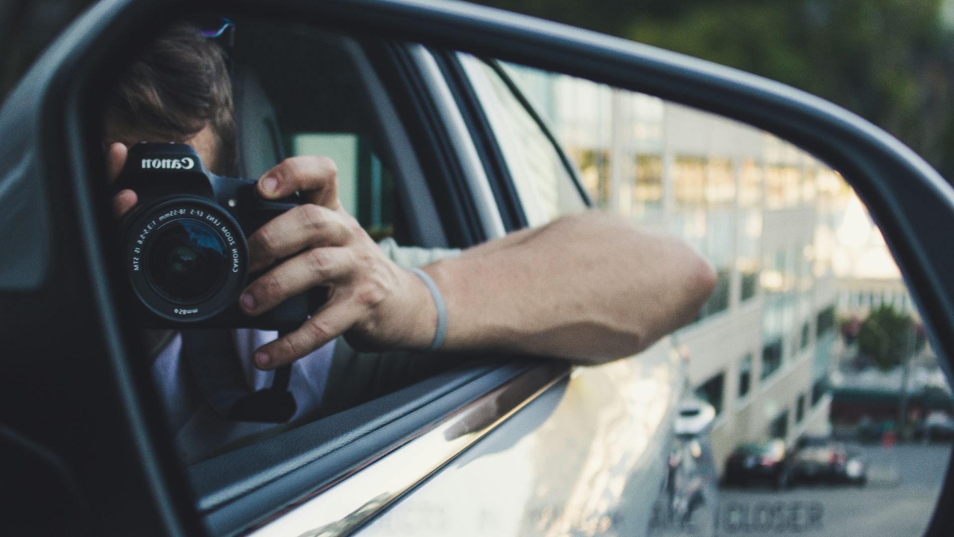 person holding black Canon DSLR camera
