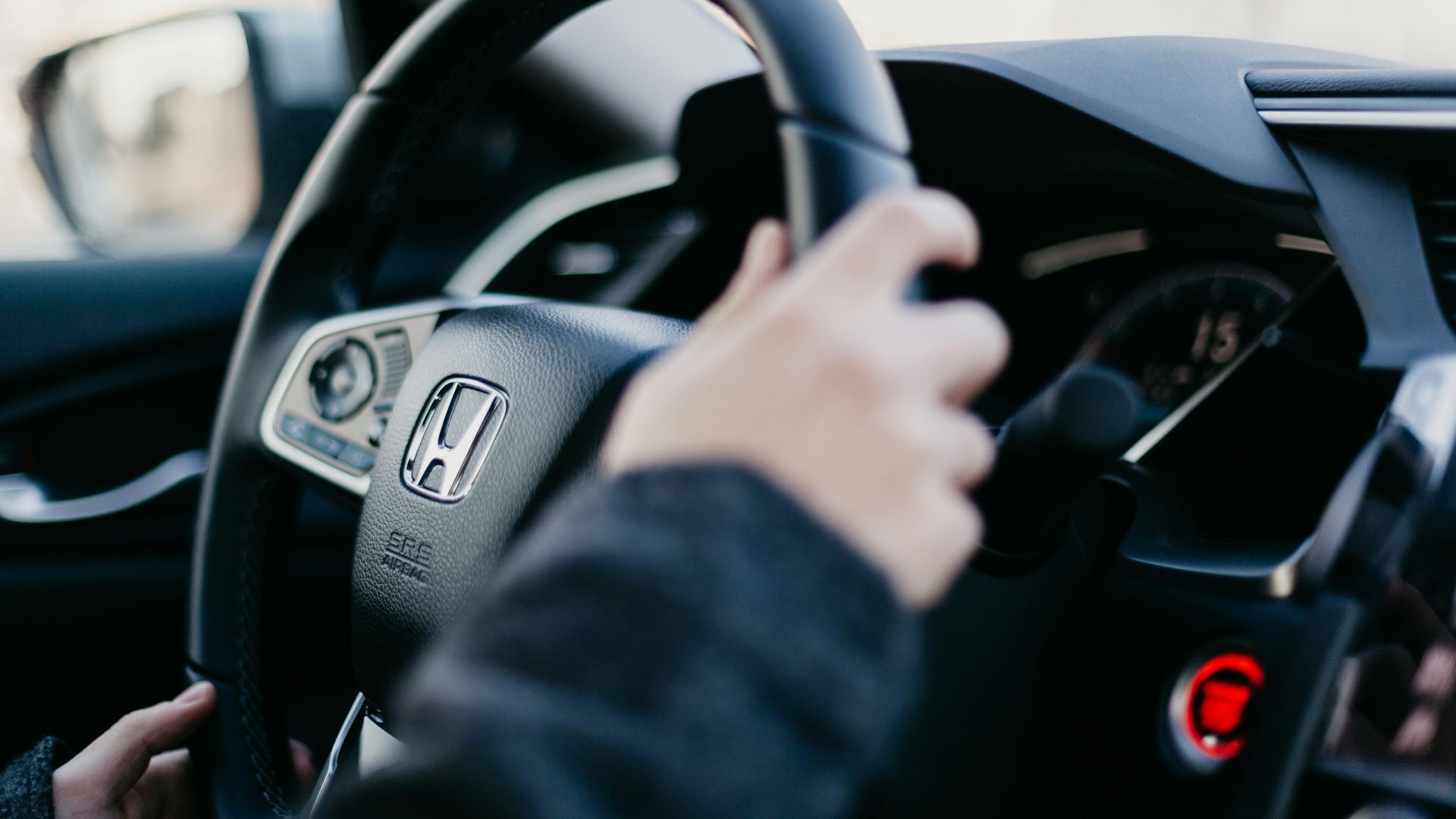 shallow focus photo of person driving Honda car