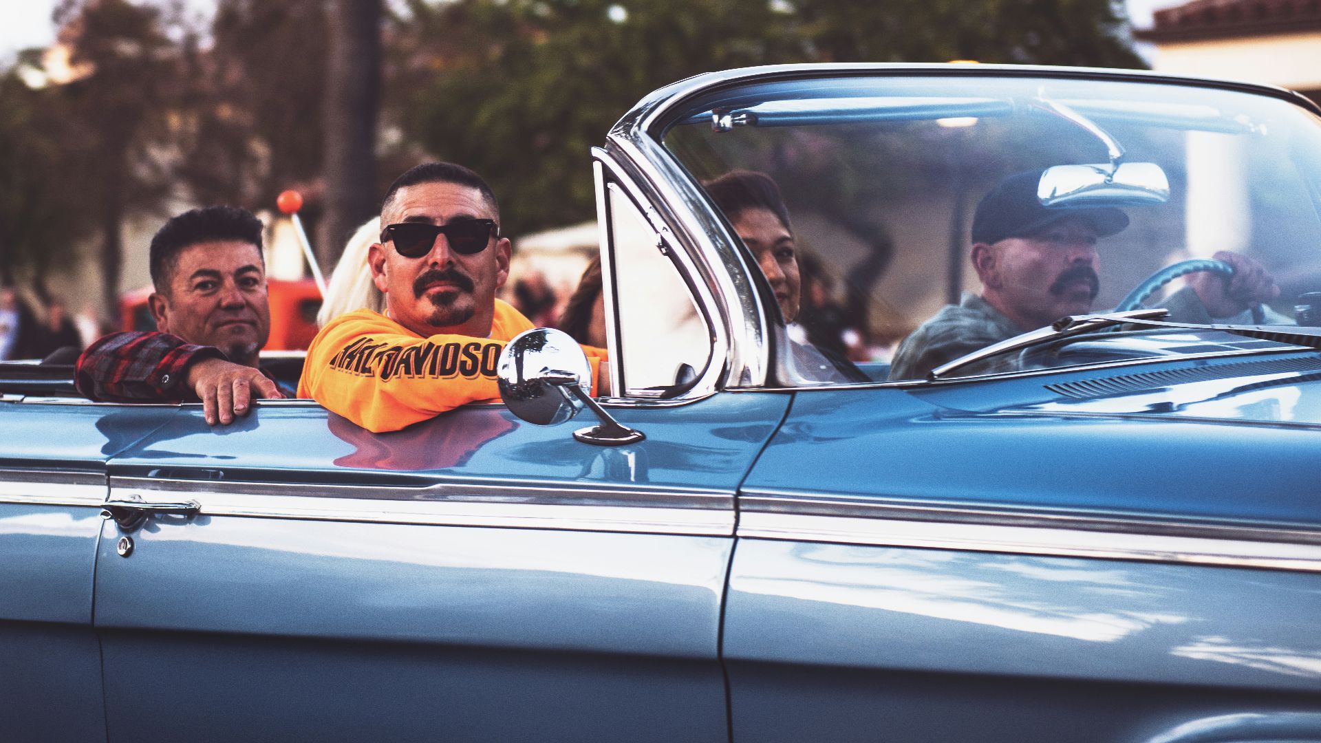 men ridding vintage convertible car