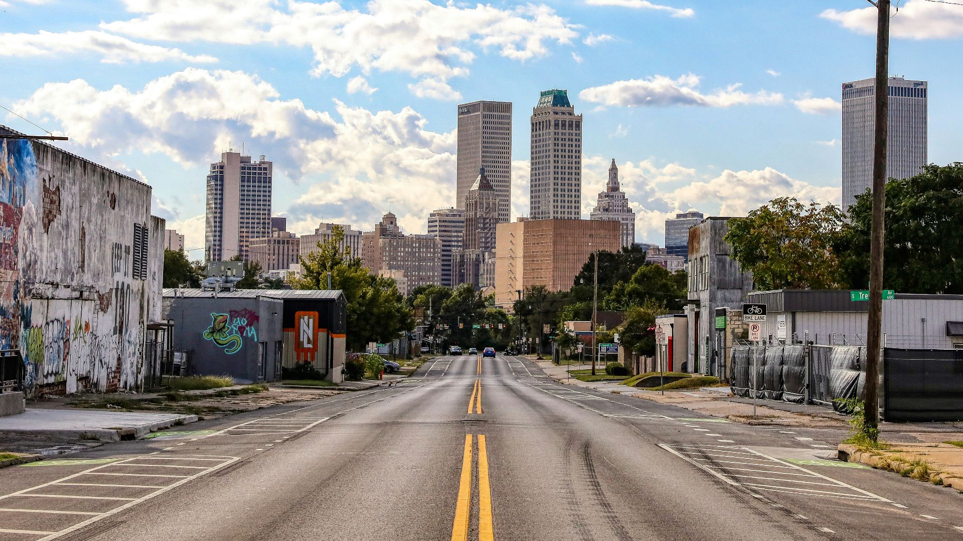 an empty street with a few buildings in the background