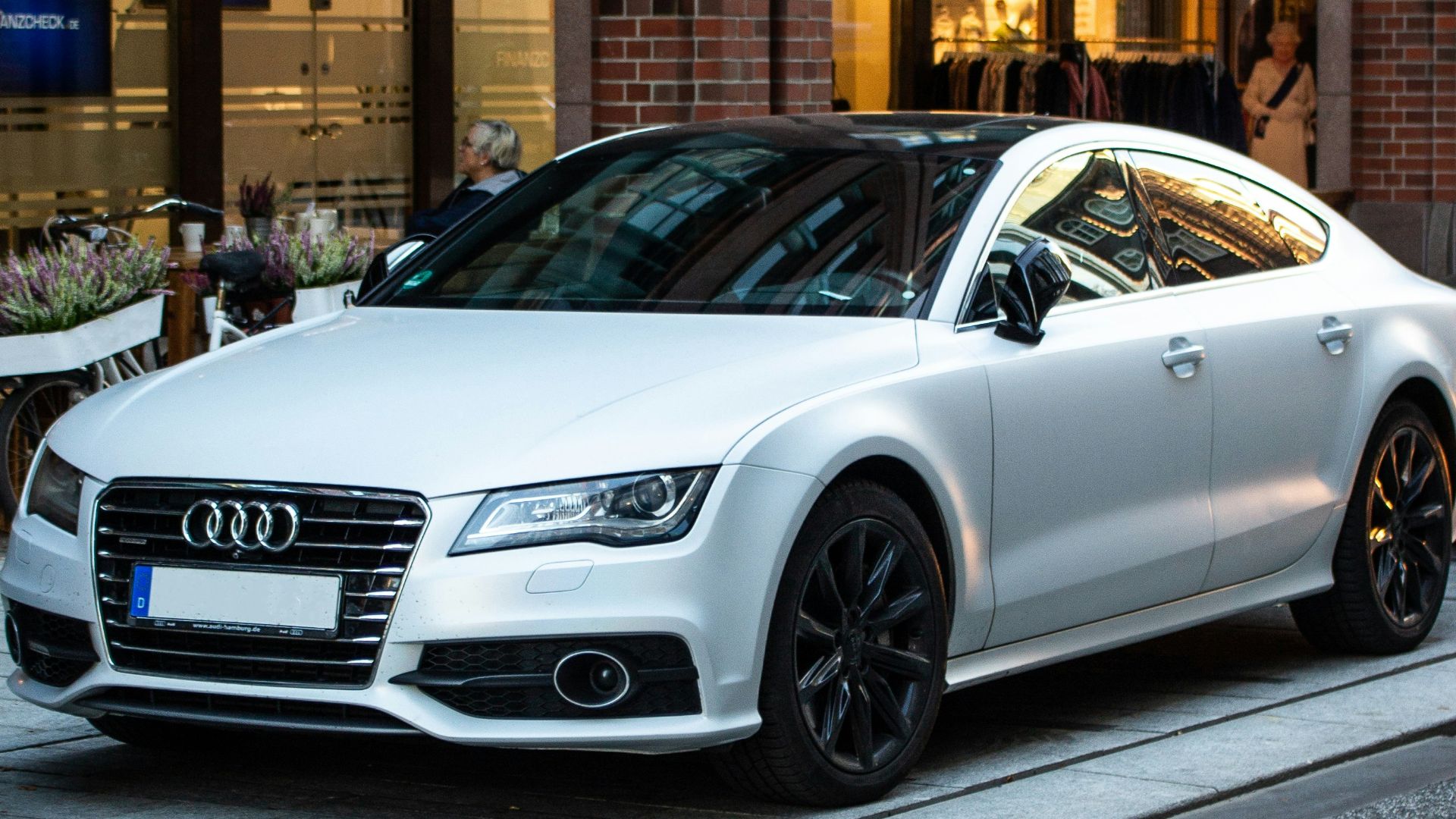 silver Audi sedan parked on street beside restore