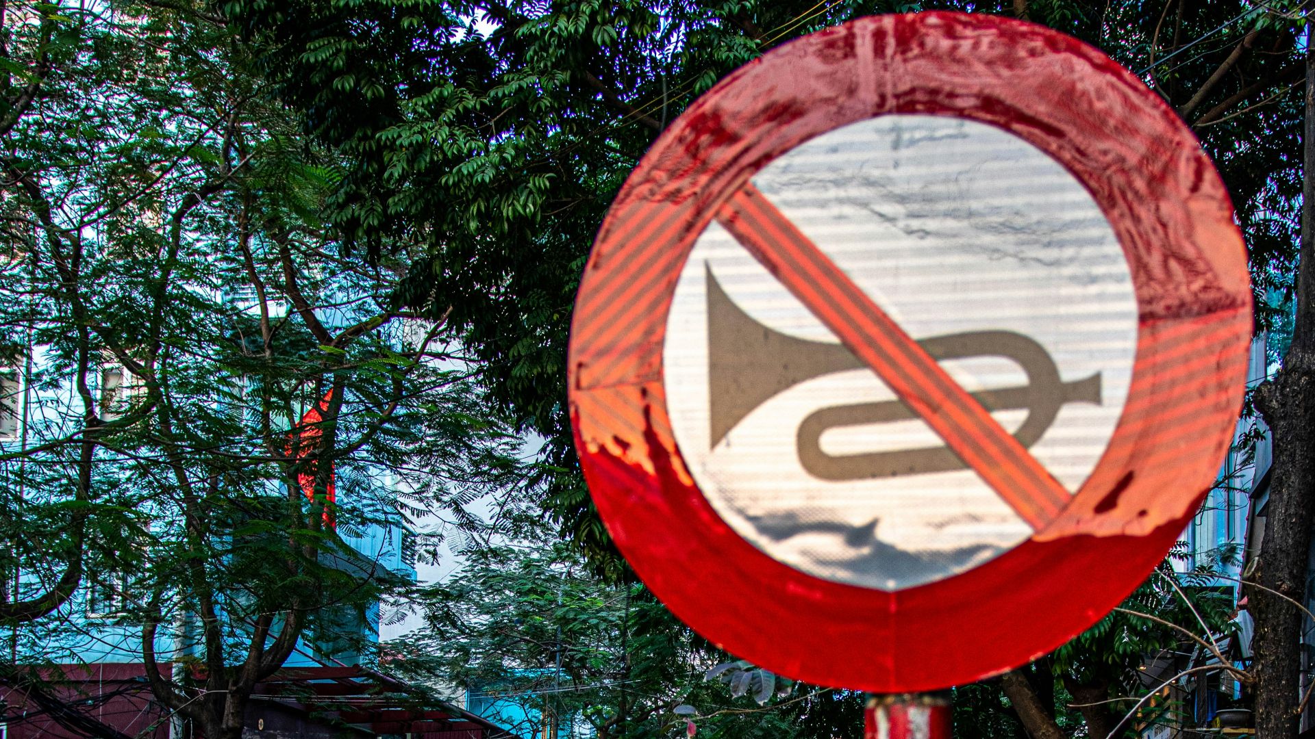 A red and white sign sitting on the side of a road