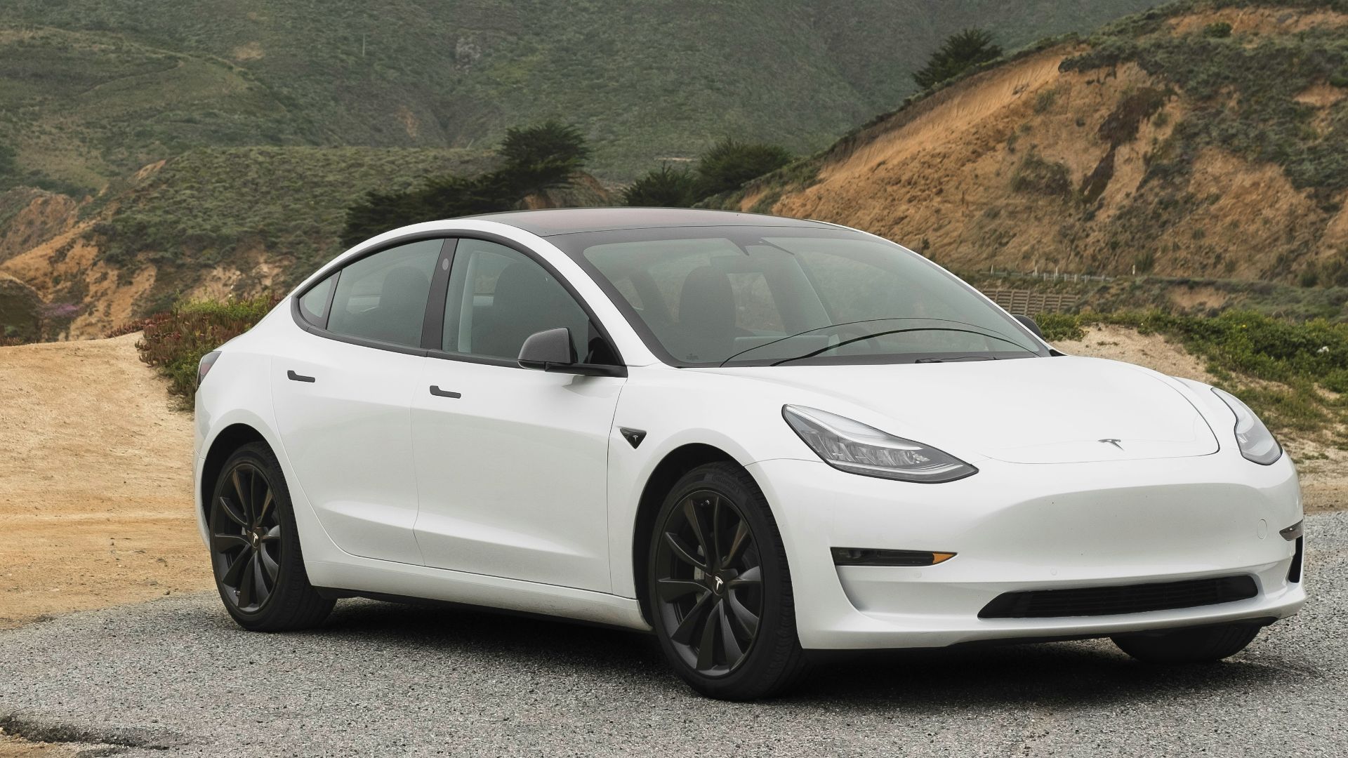 white sedan parked beside mountain during daytime