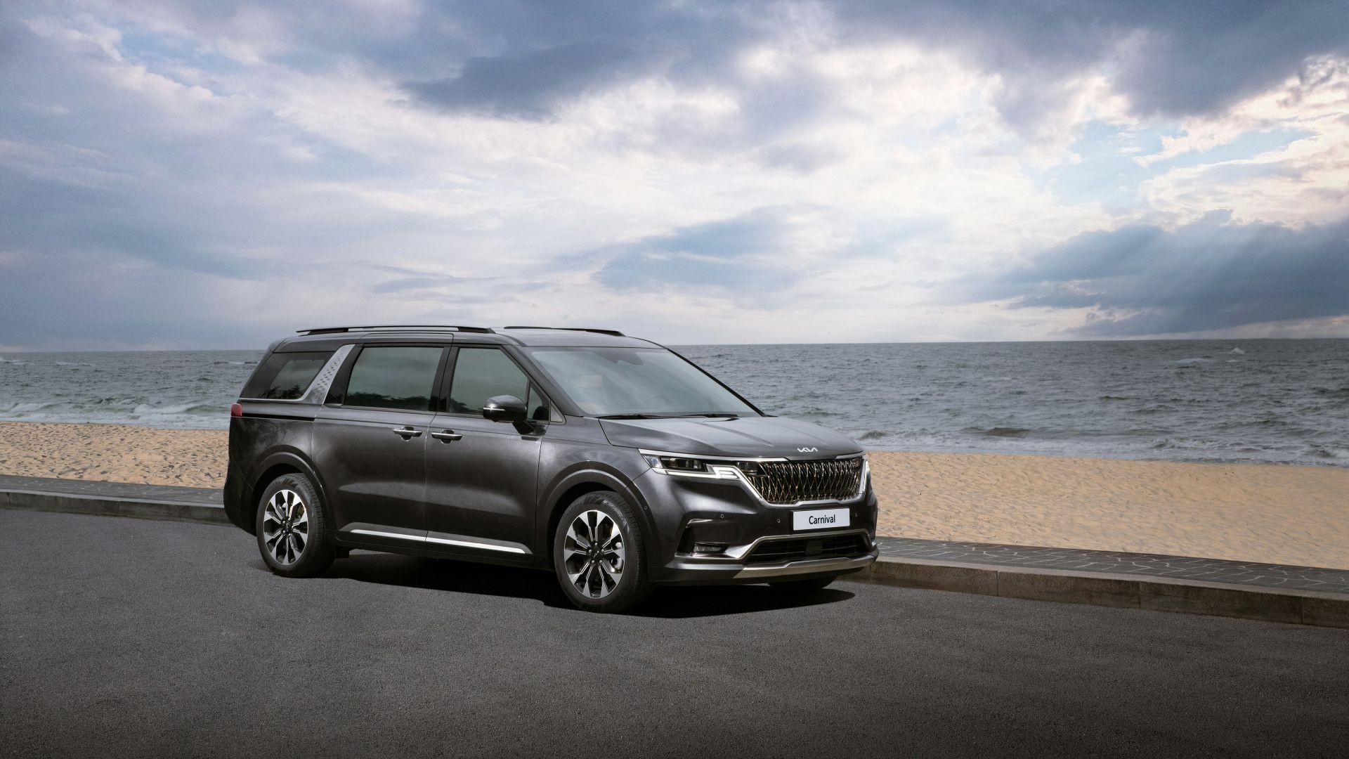 a grey suv parked on the side of a road near the ocean