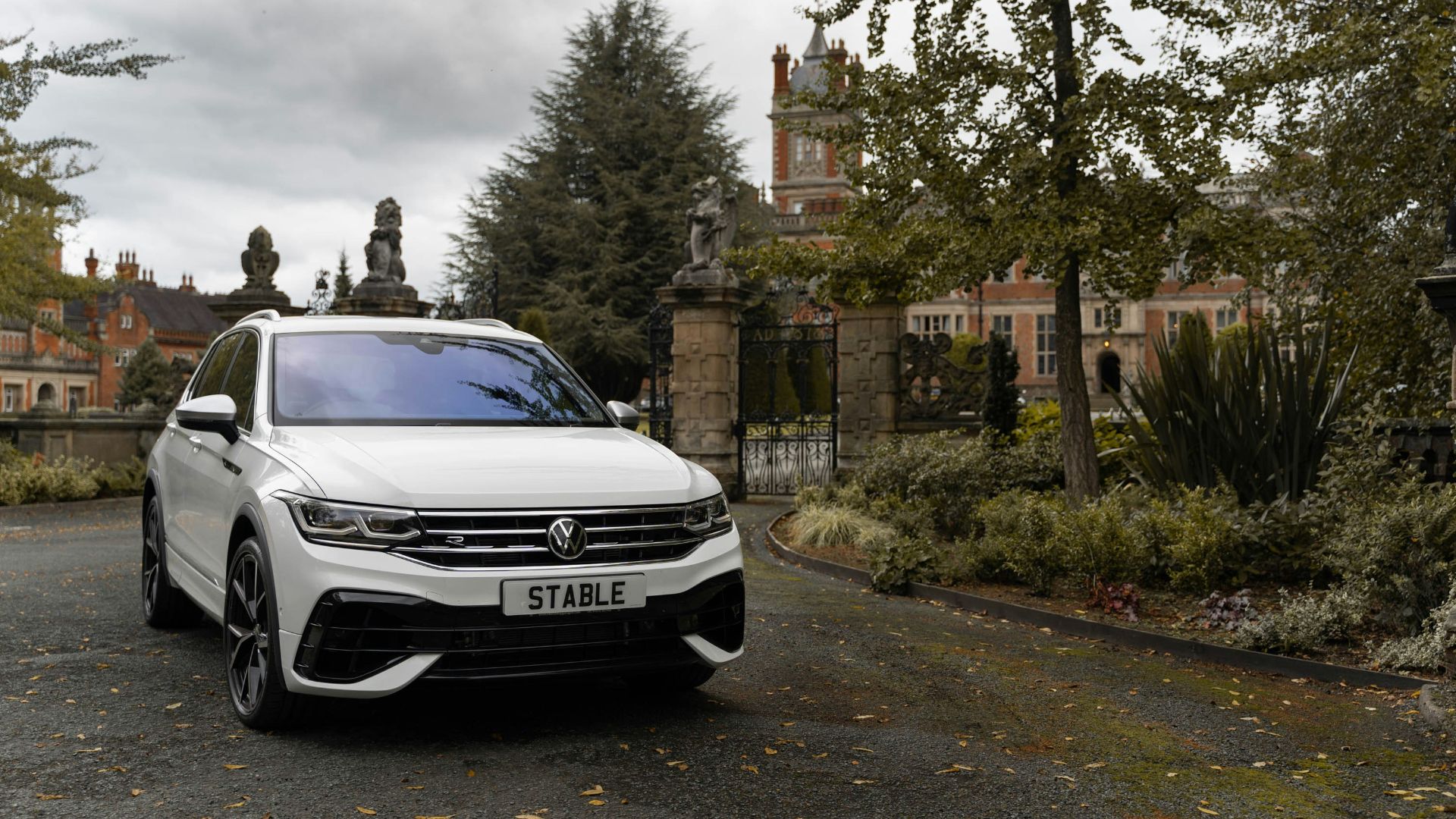 a white car parked in front of a gated building