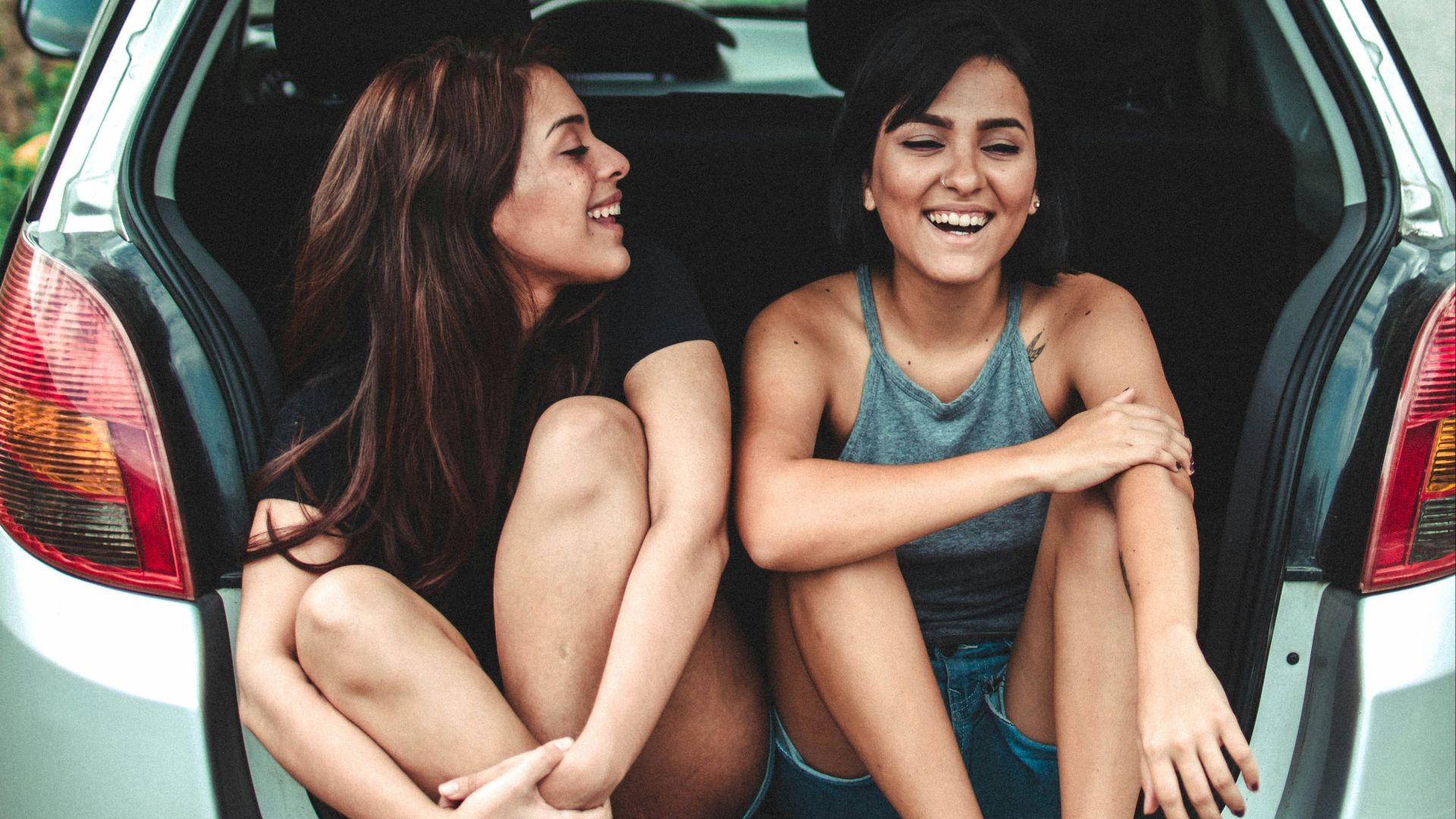 two women sitting at the back of the car