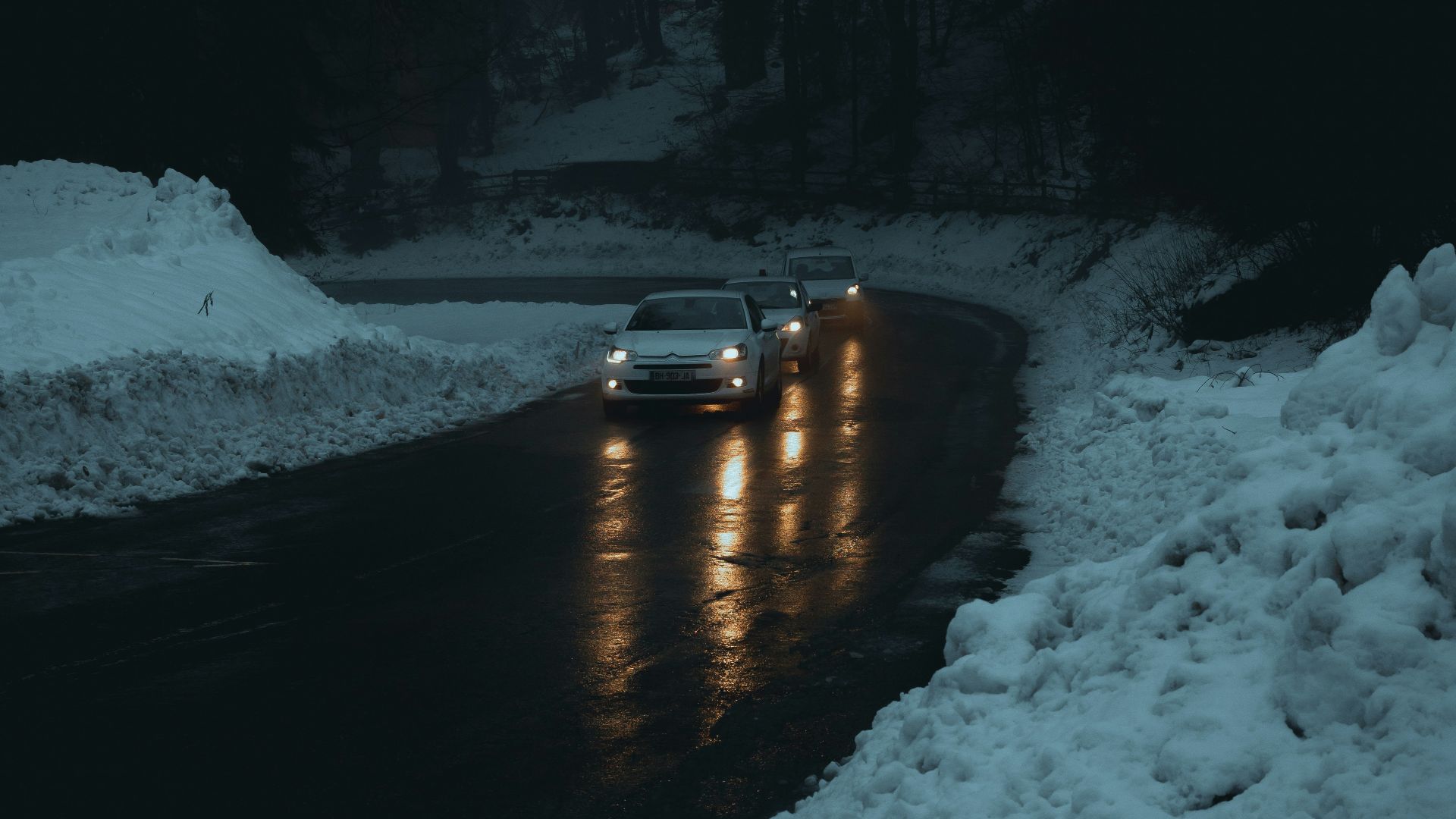 a car driving down a snowy road at night