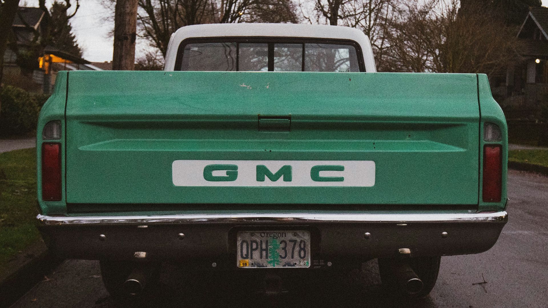 green chevrolet pickup truck parked on road side during daytime