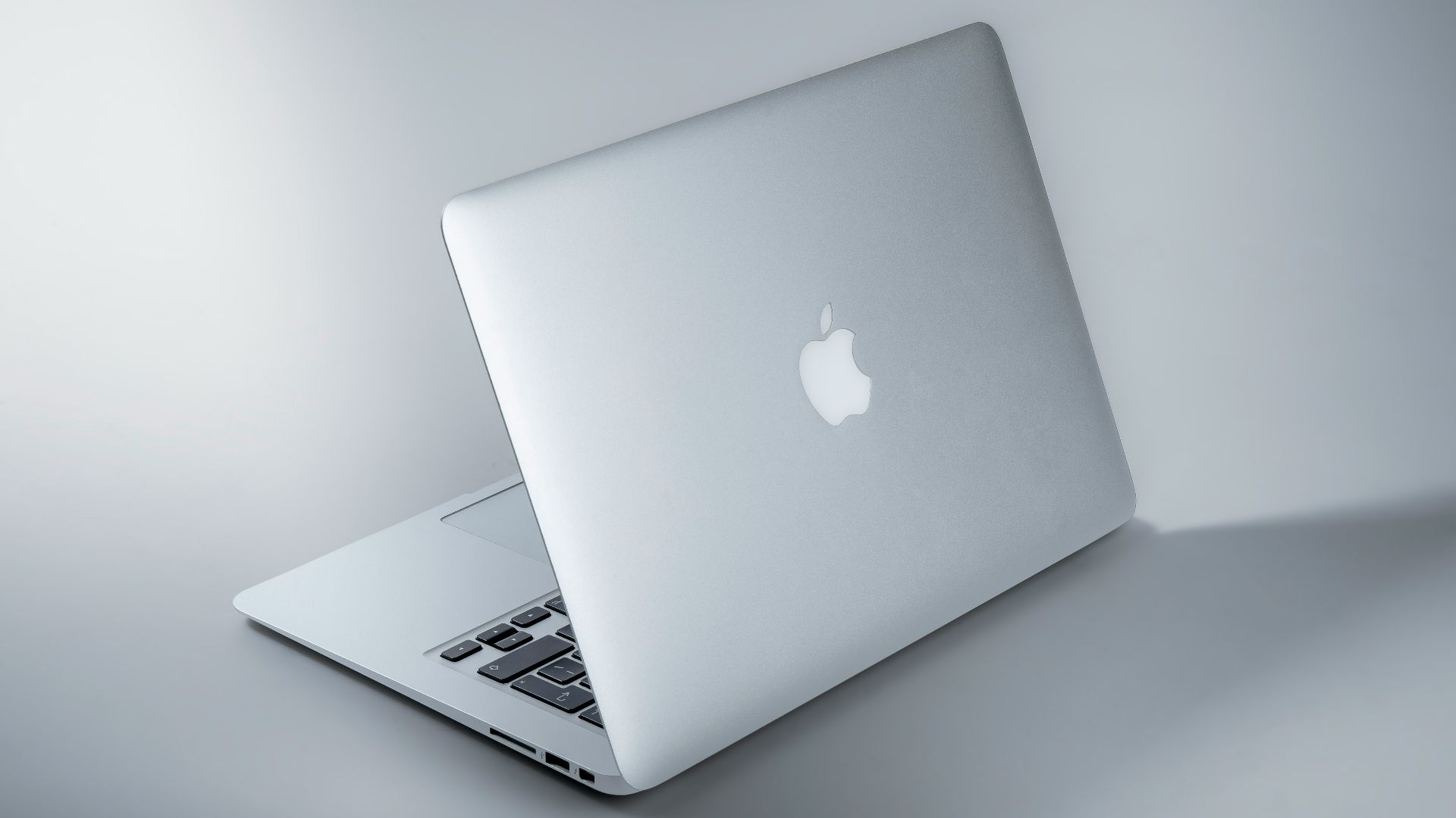 silver macbook on white table
