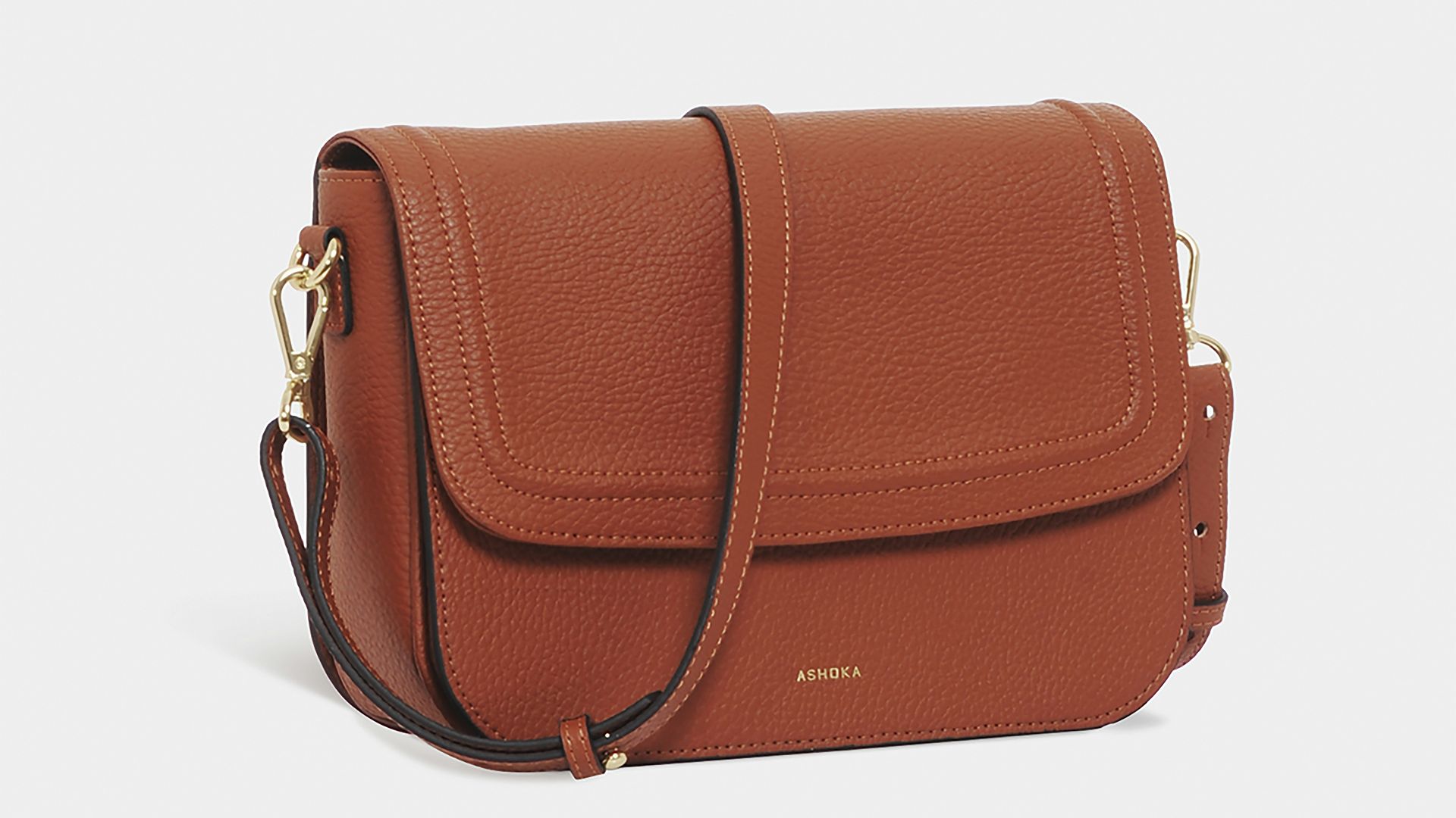 brown leather sling bag on white background