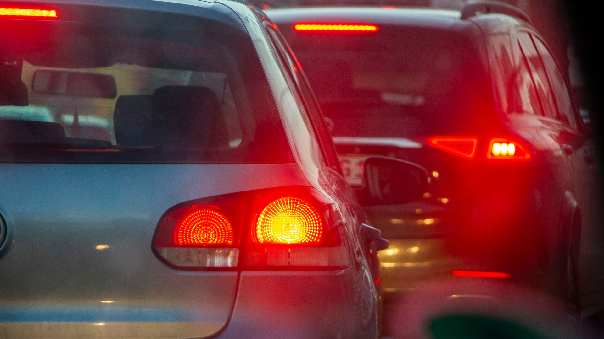a group of cars driving down a street next to each other