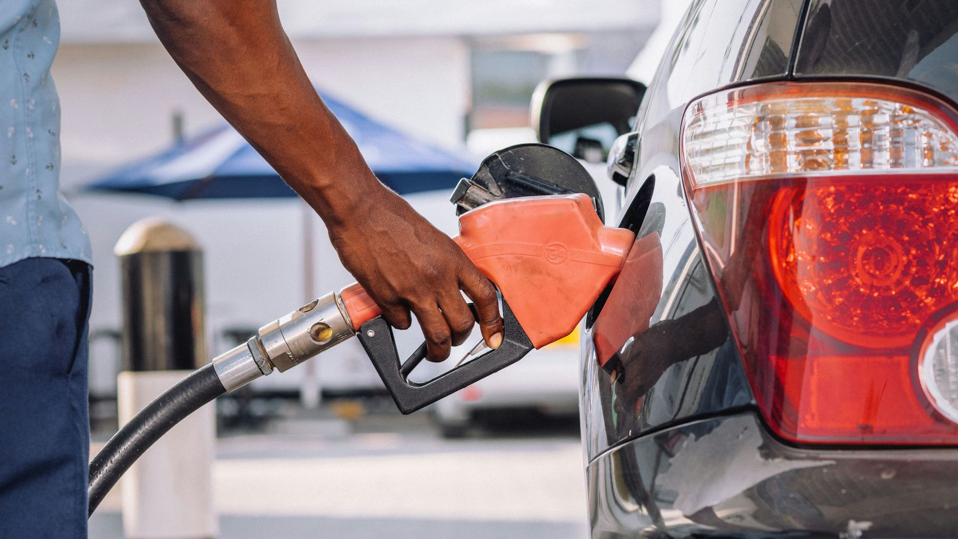 a man pumping gas into his car at a gas station