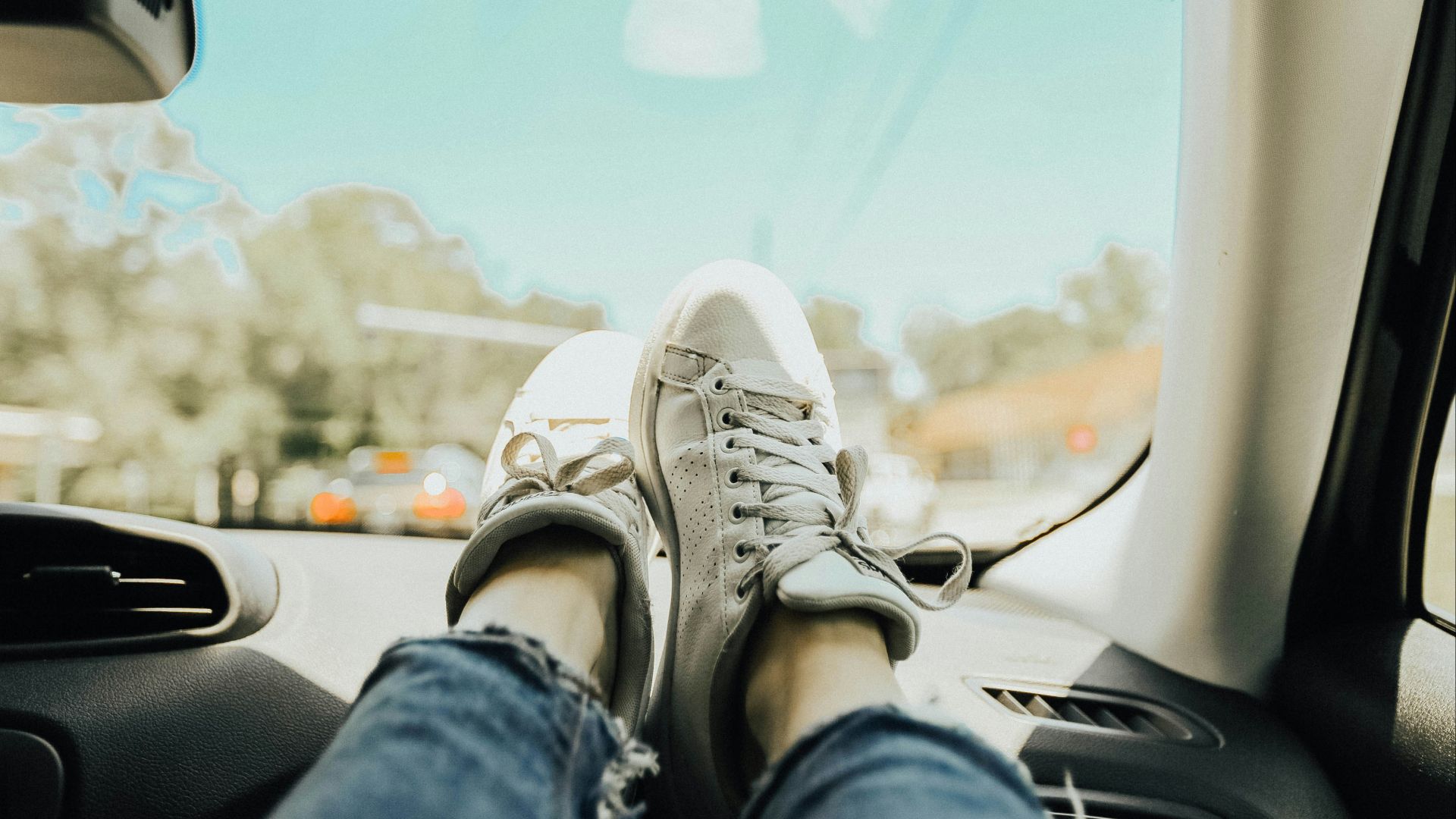 person resting feet on car dashboard
