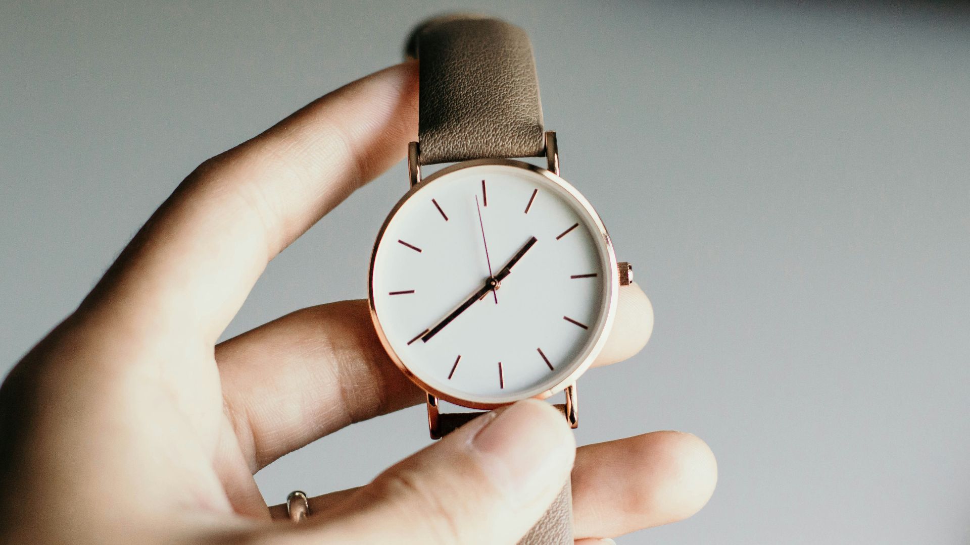 person holding analog watch