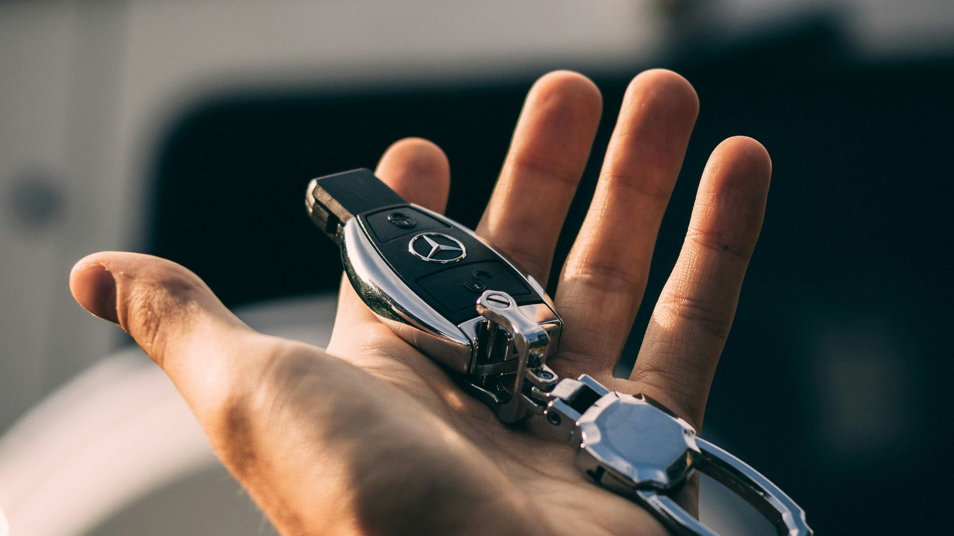 person holding Mercedes-Benz fob
