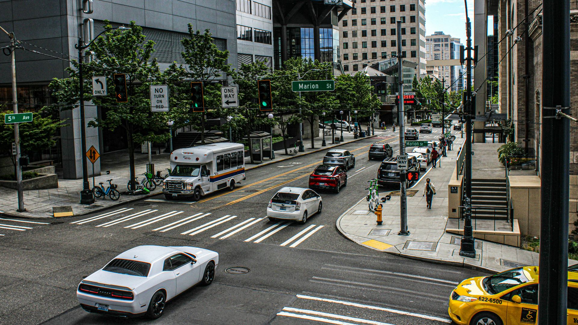 A city street filled with lots of traffic next to tall buildings