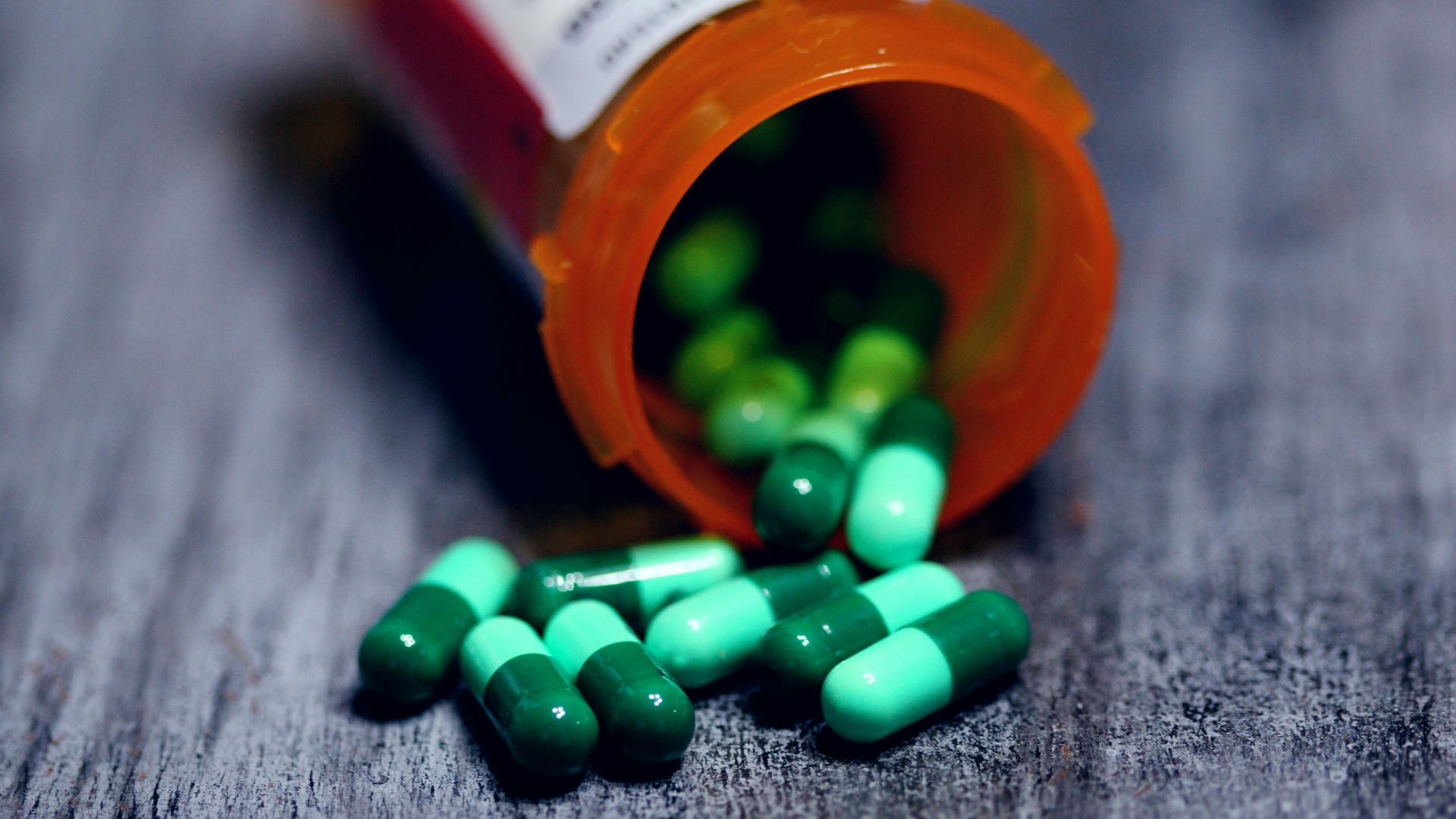 shallow focus photography of prescription bottle with capsules
