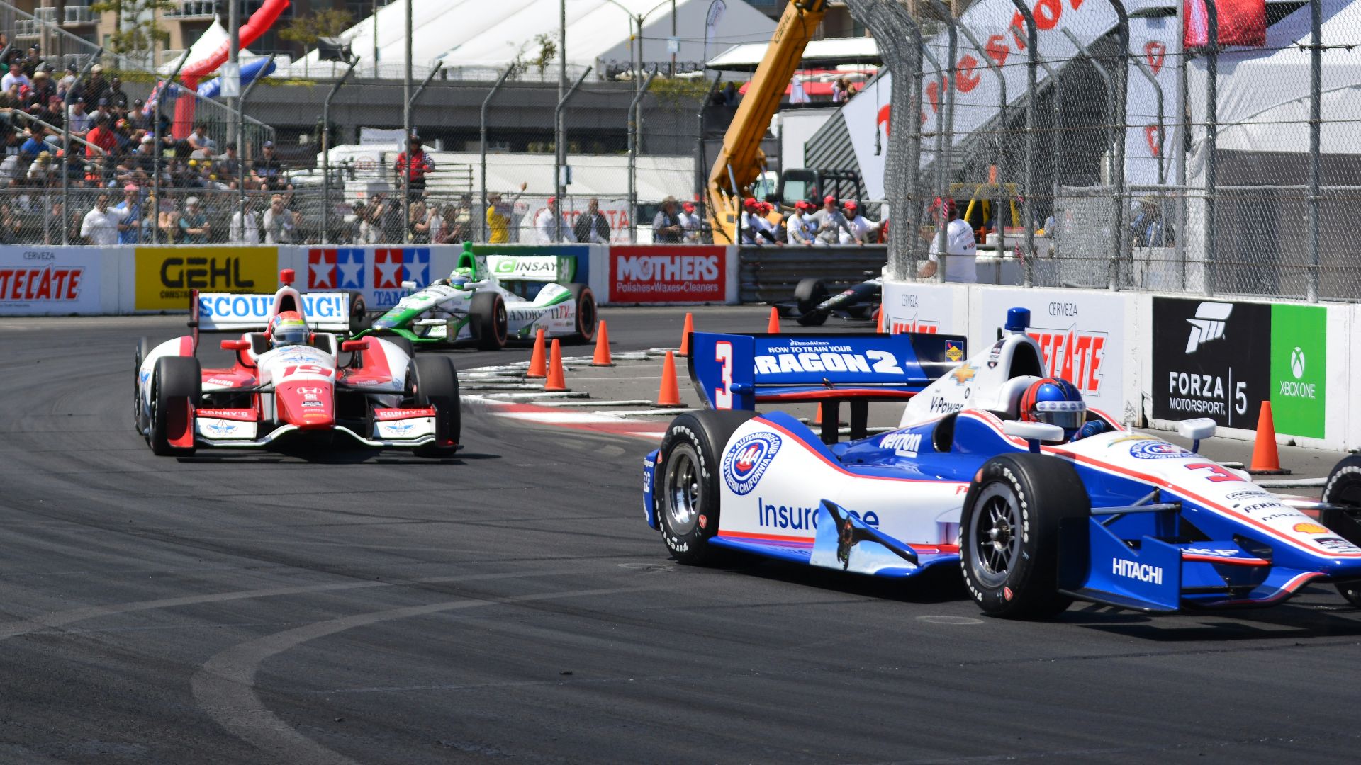 a group of racing cars driving down a race track