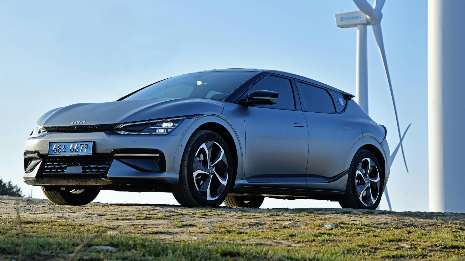a car parked in front of a wind turbine