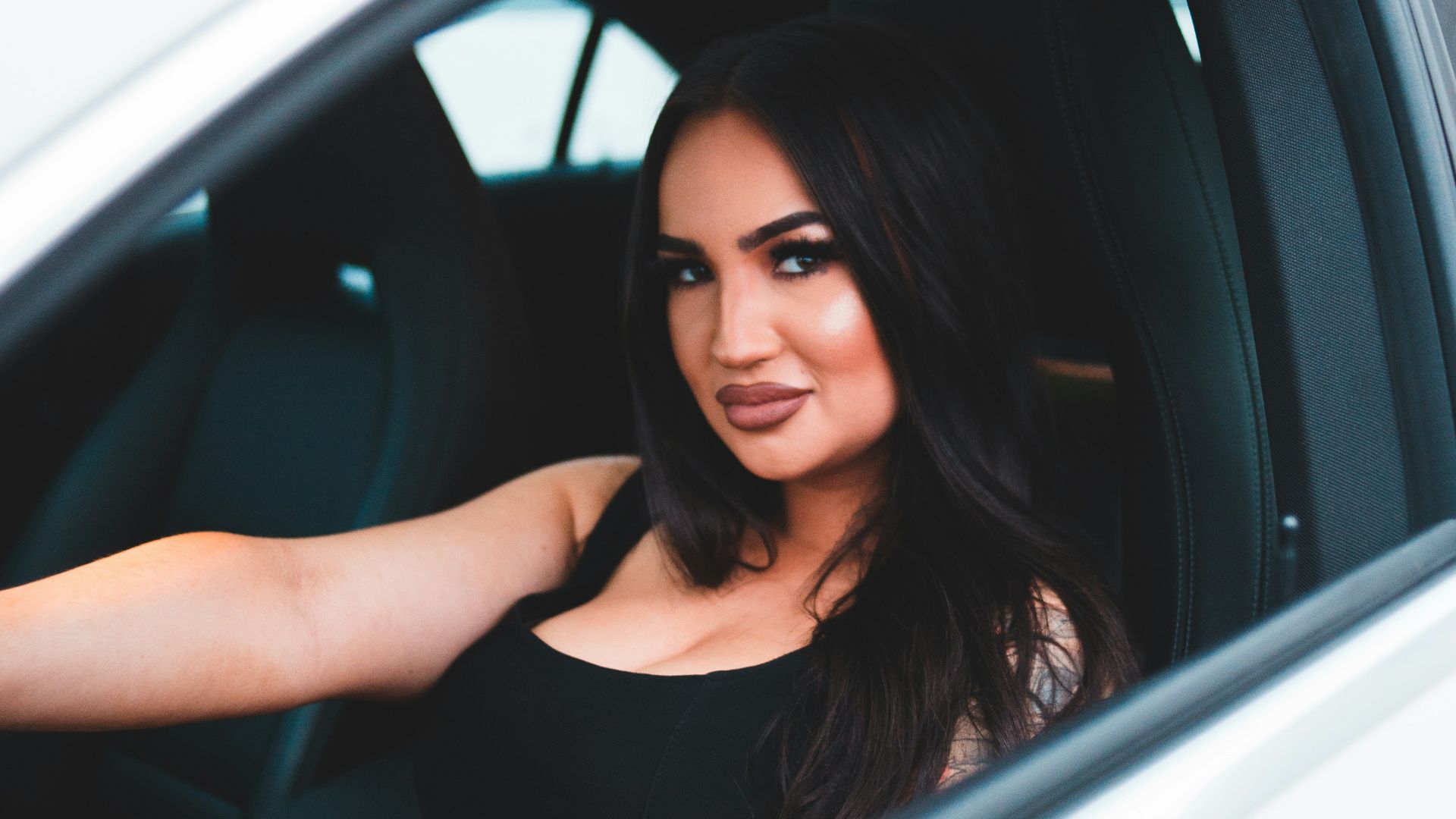 woman in black tank top sitting inside car