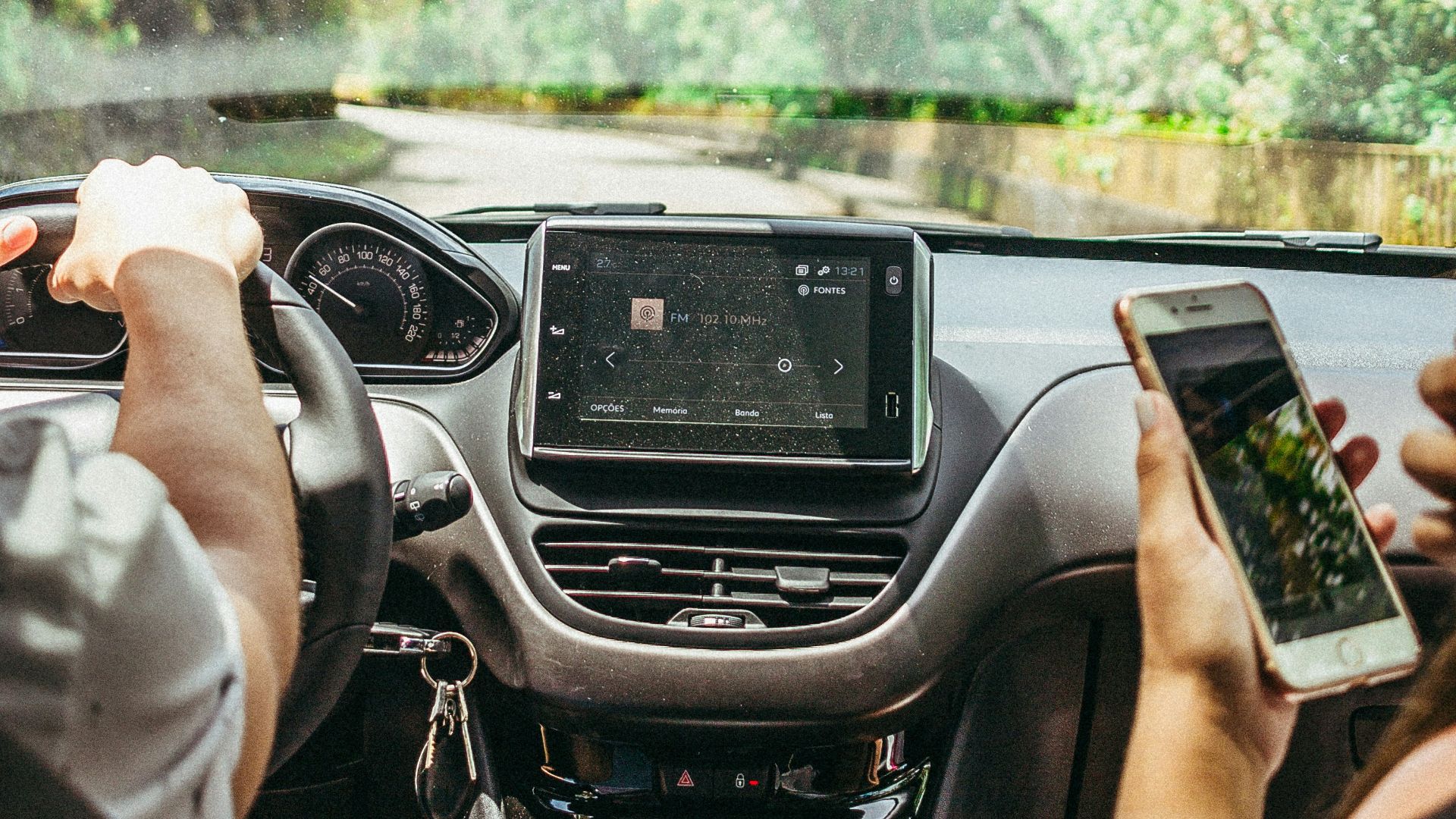 man at the car seat holding his phone beside the driver