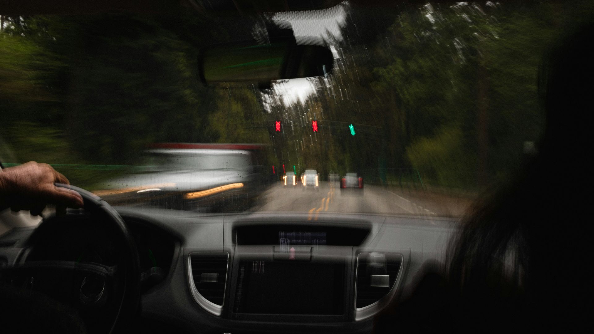 a person driving a car on a road with traffic lights
