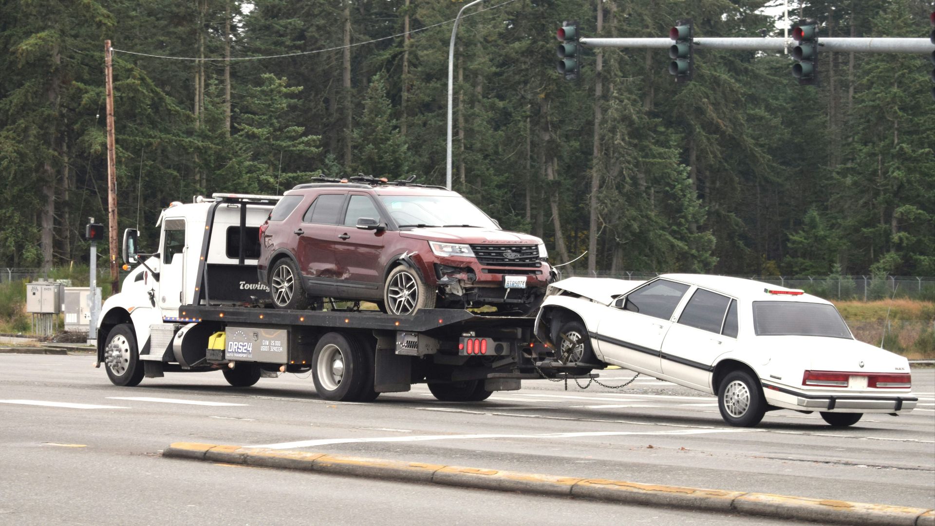 A tow truck towing a car on the road
