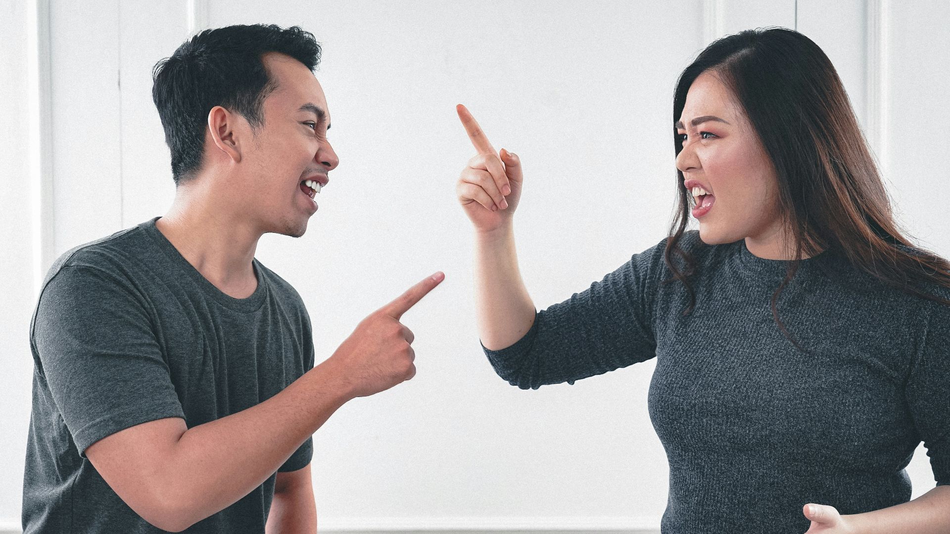 man in gray crew neck long sleeve shirt standing beside woman in black crew neck shirt