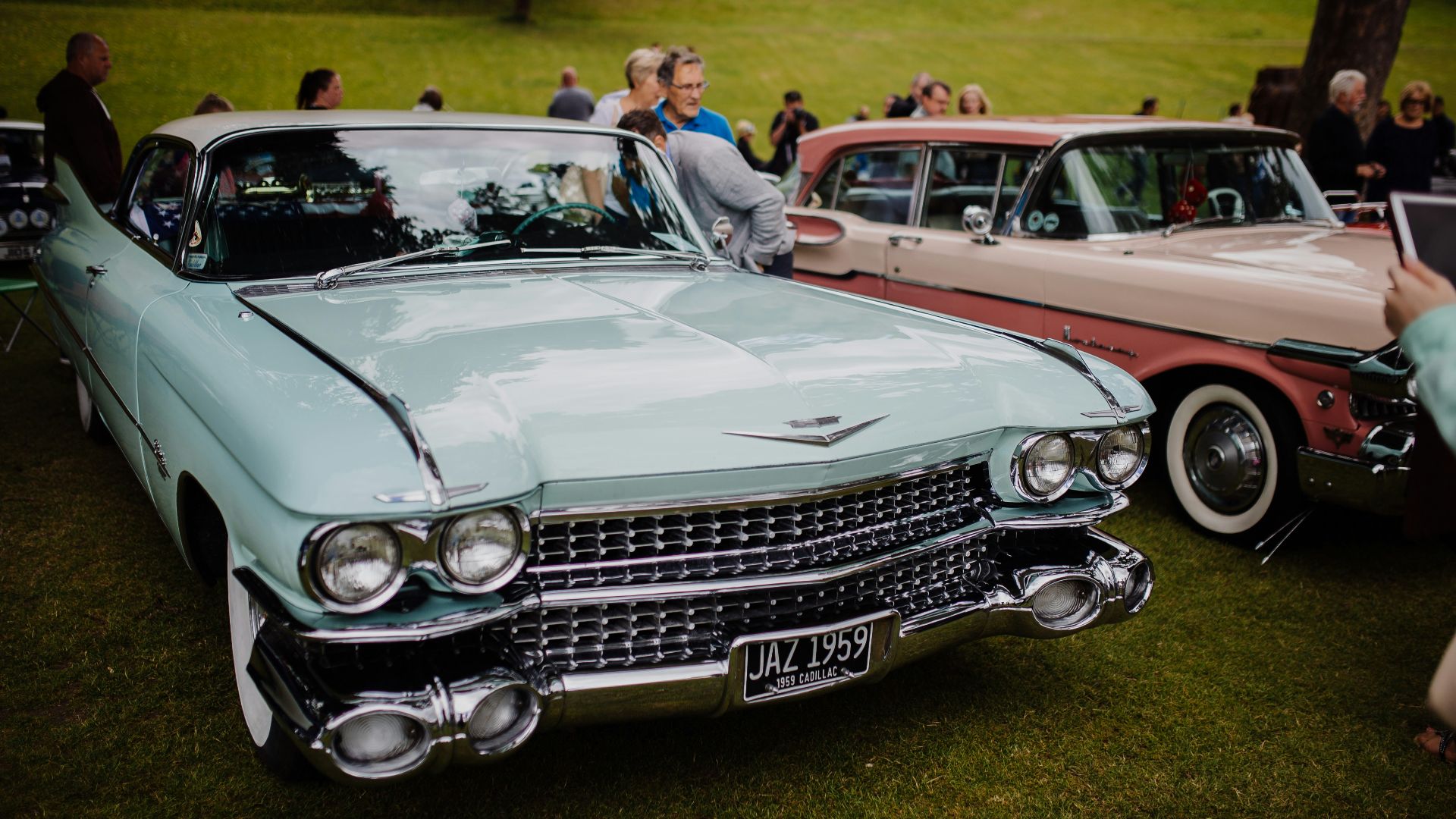 people standing beside red and white vintage car during daytime