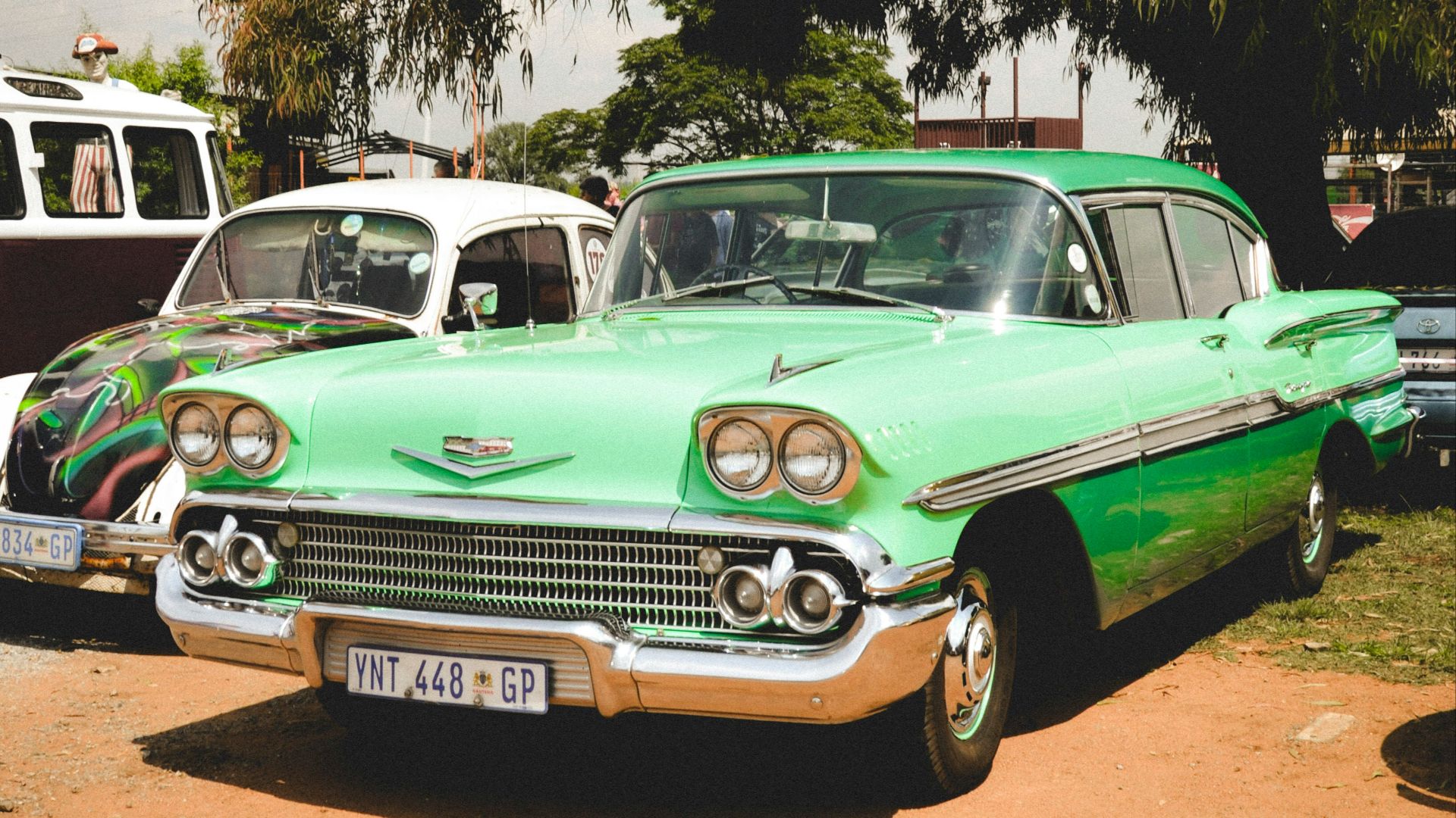 Vintage cars are parked outdoors on a sunny day.