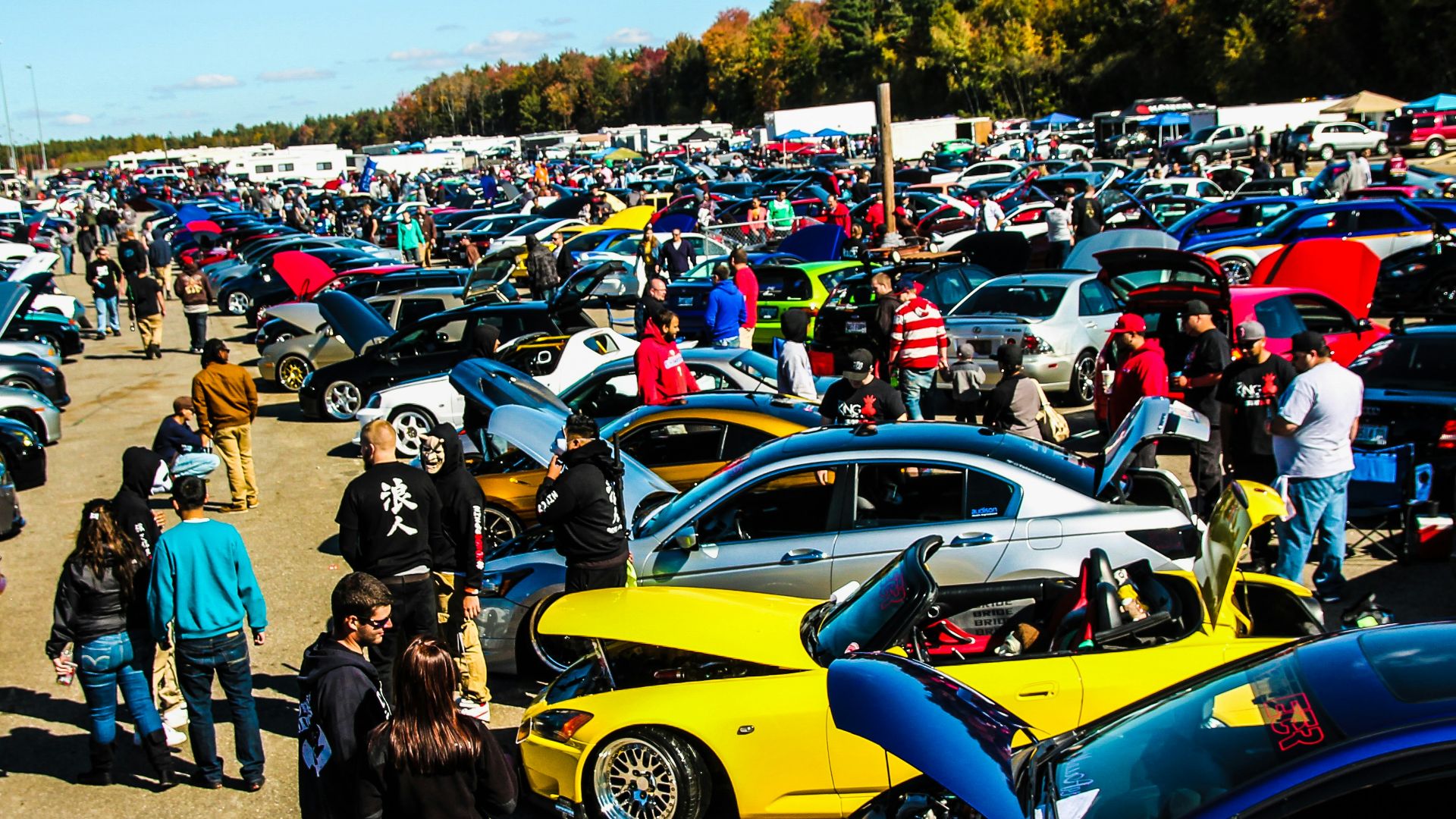 people standing beside blue and yellow cars during daytime