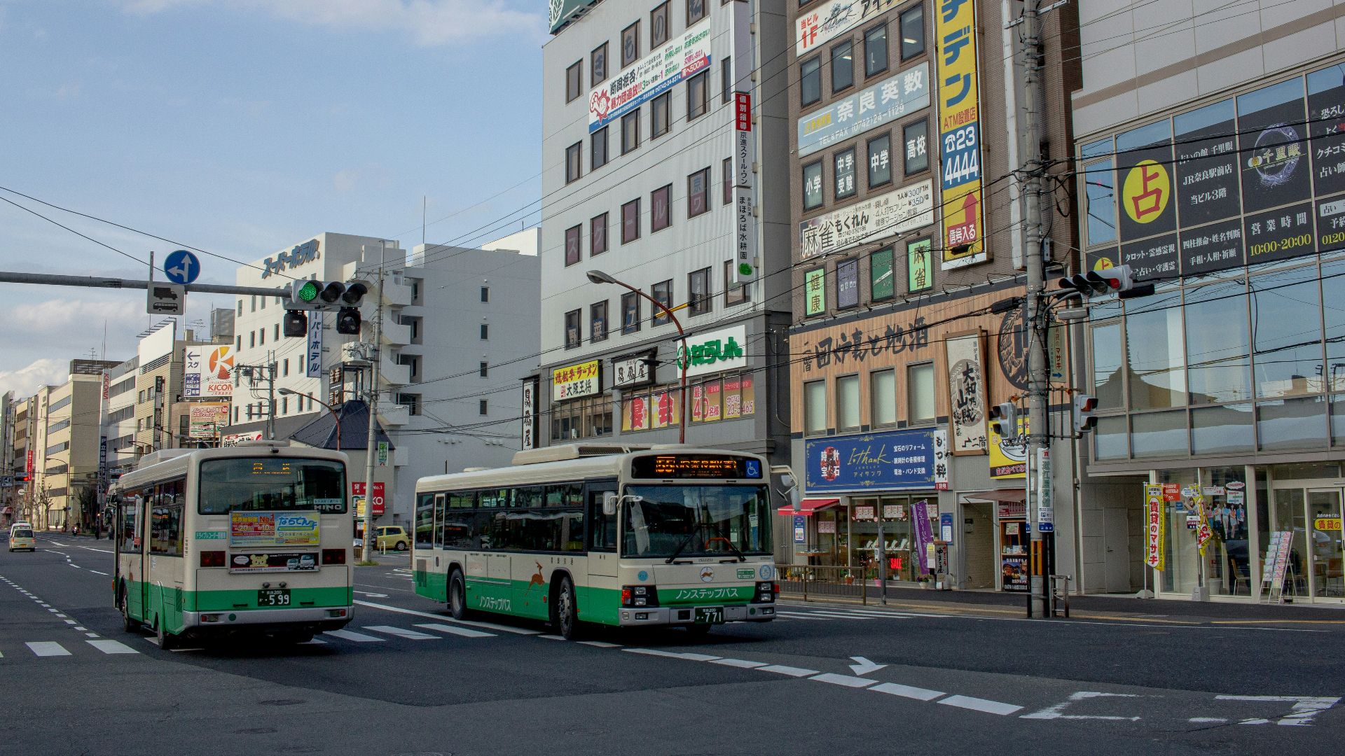 two white-and-green buses on road during daytime