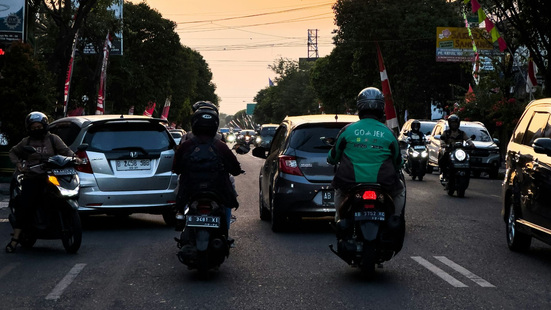 A group of people riding motorcycles down a street