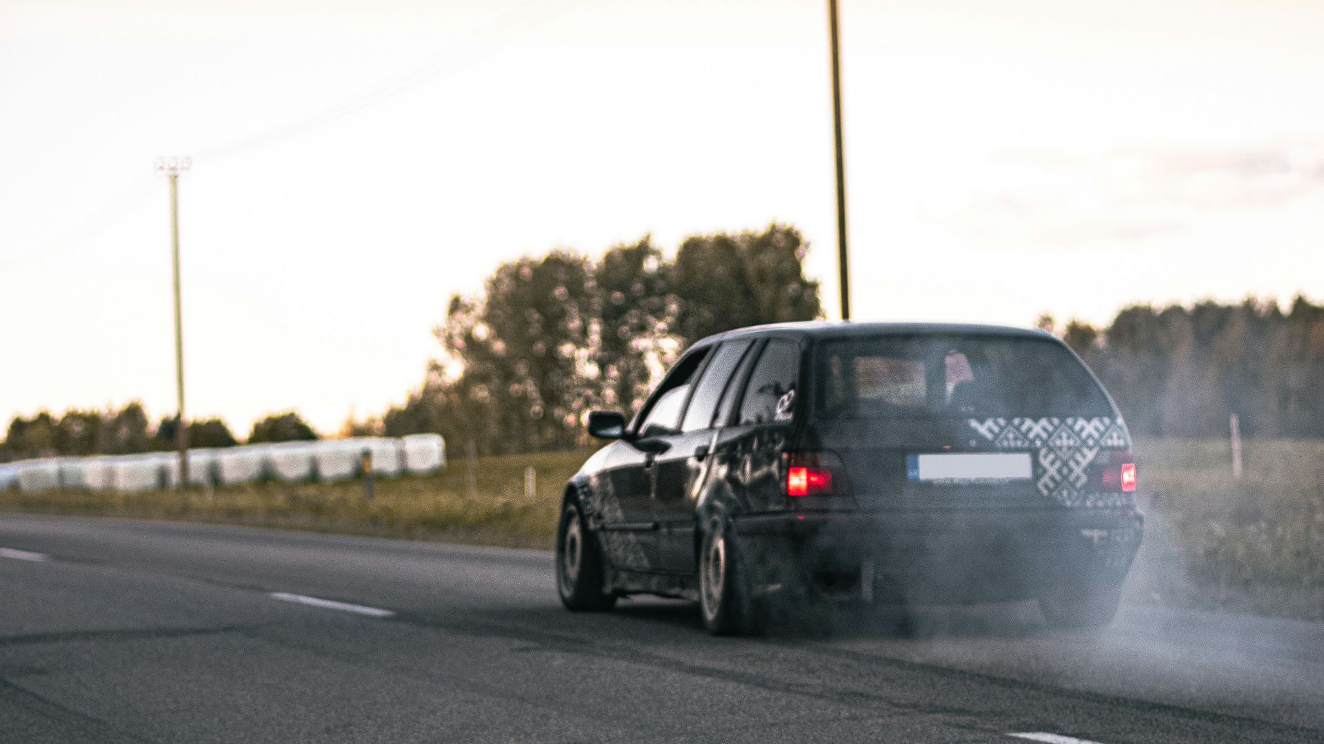 a car driving down the road with a lot of smoke coming out of it