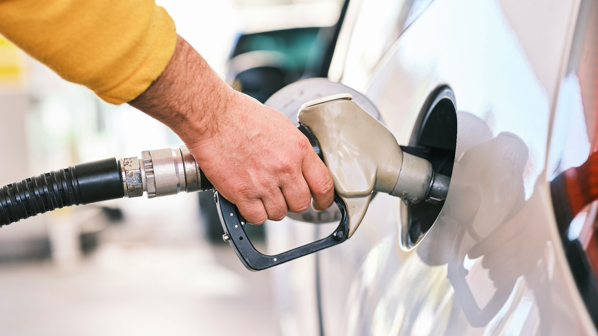 a man pumping gas into his car at a gas station