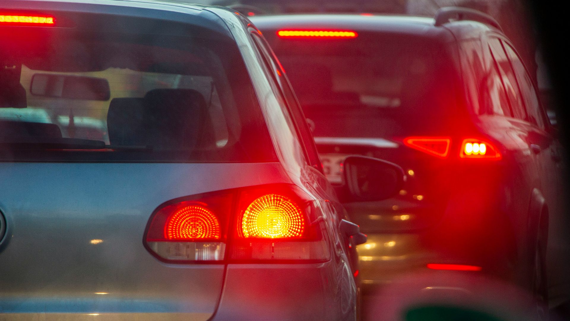 a group of cars driving down a street next to each other