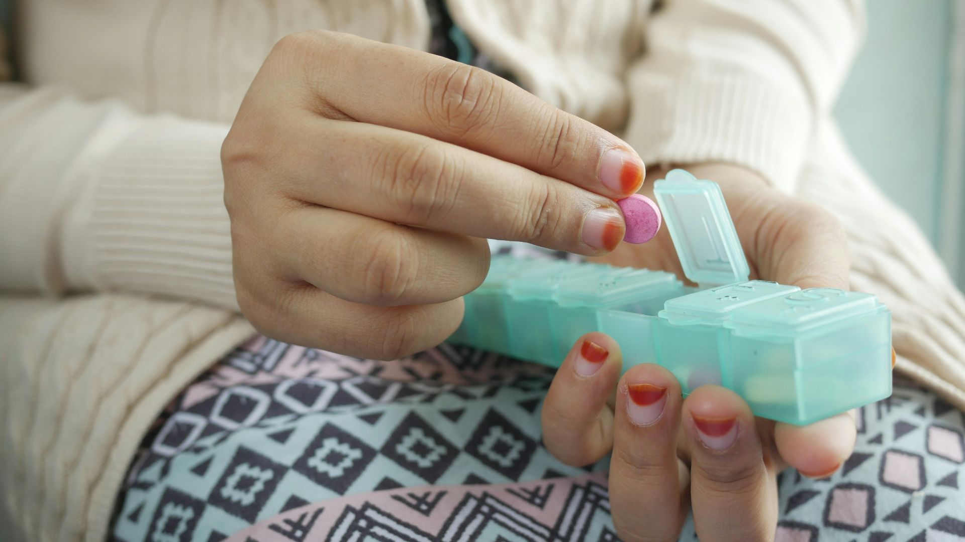 person holding white and green plastic container