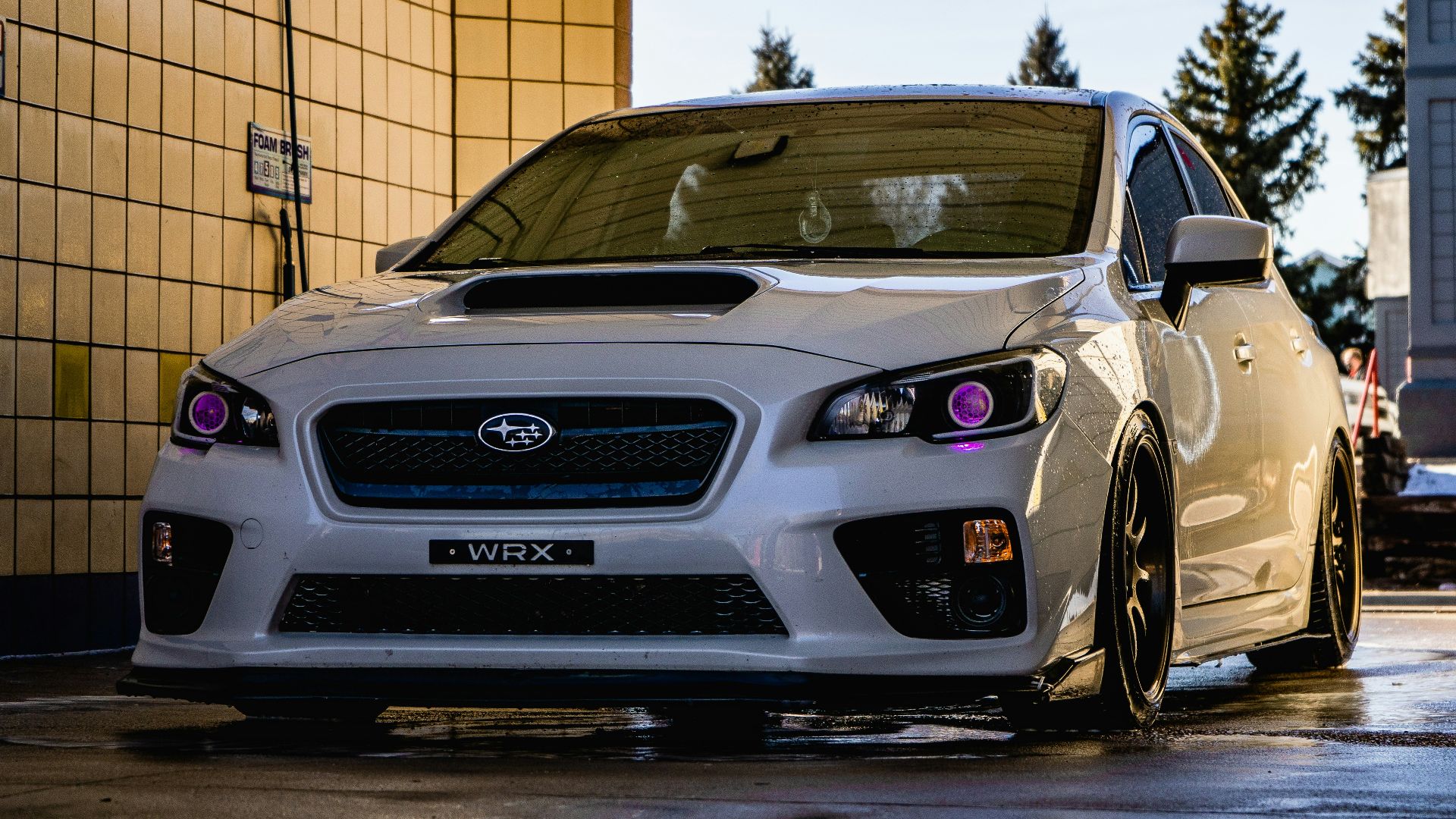 white honda car parked beside brown brick wall