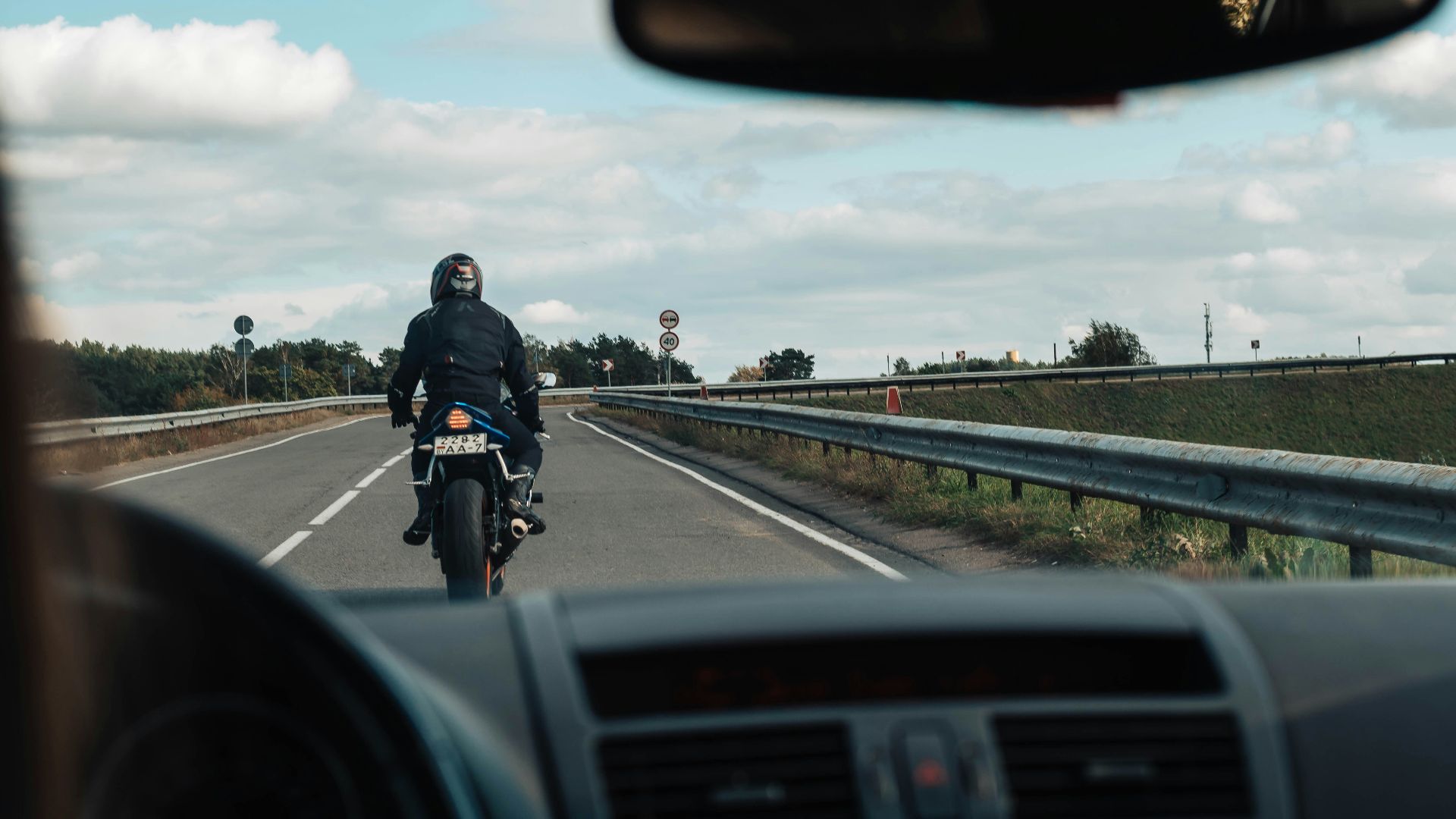 man in black jacket riding motorcycle on road during daytime