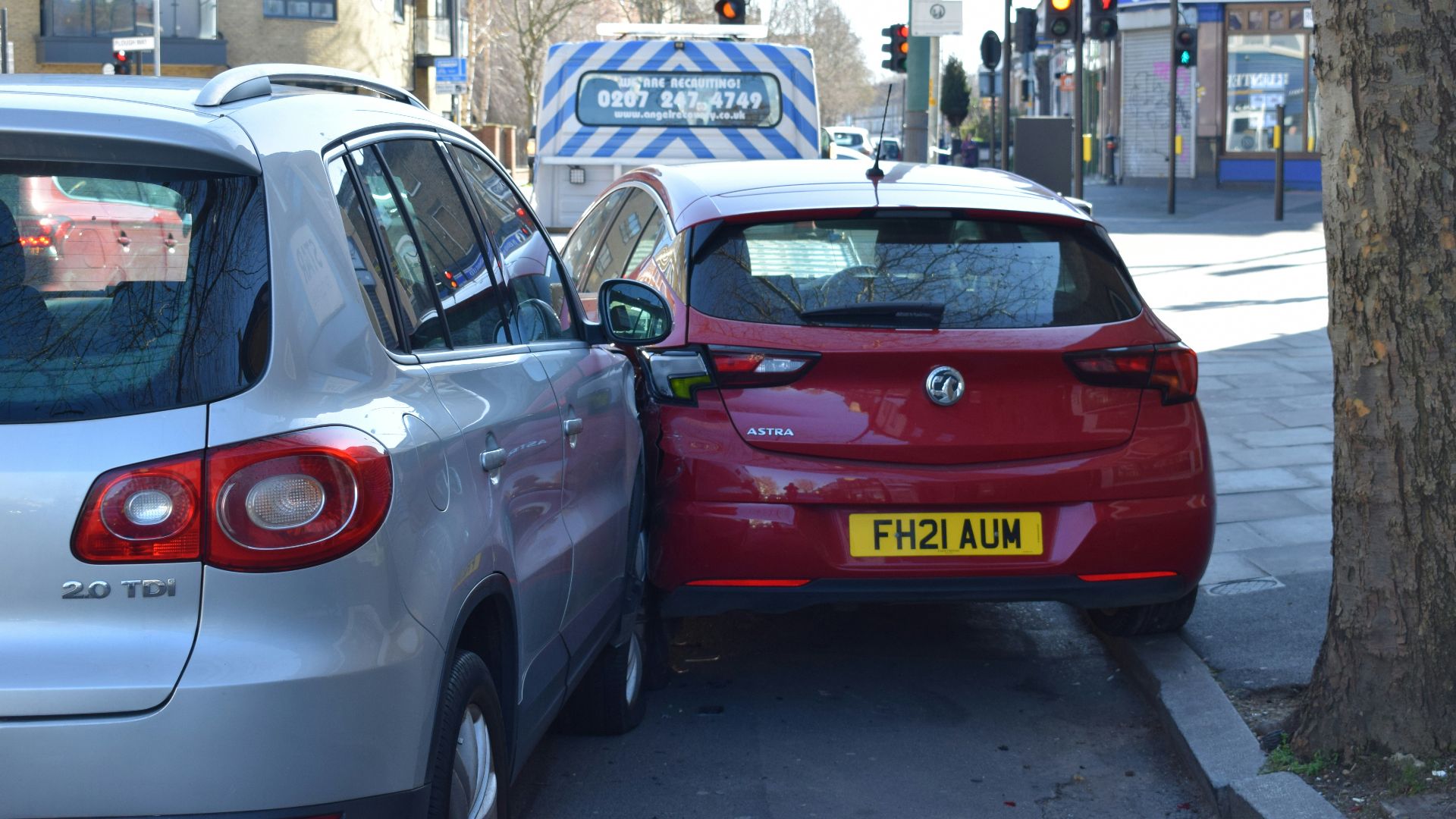 a red car is parked next to a silver car